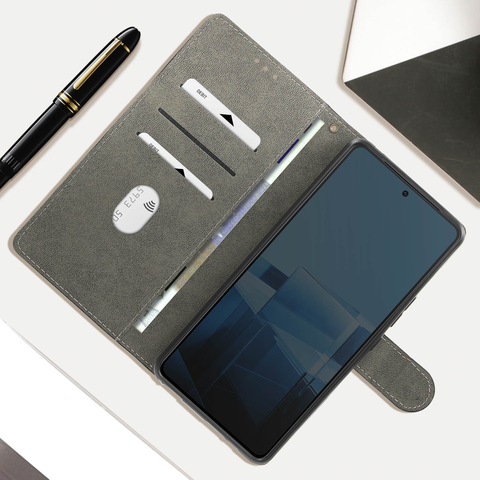 Geöffnete graue Handyhülle mit Telefon, Karten und Geld. Stift links.