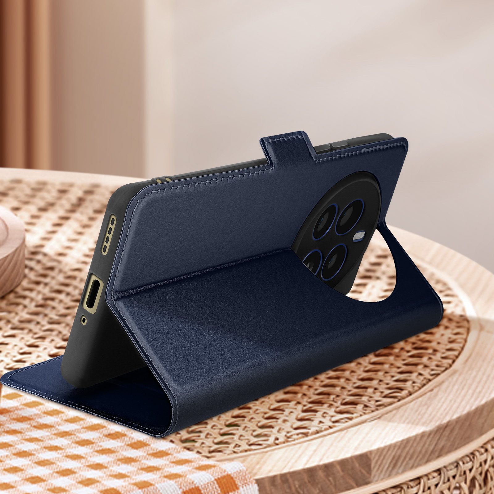 Custodia per telefono blu scuro, aperta e in piedi. Telefono visibile. Tavolo legno.