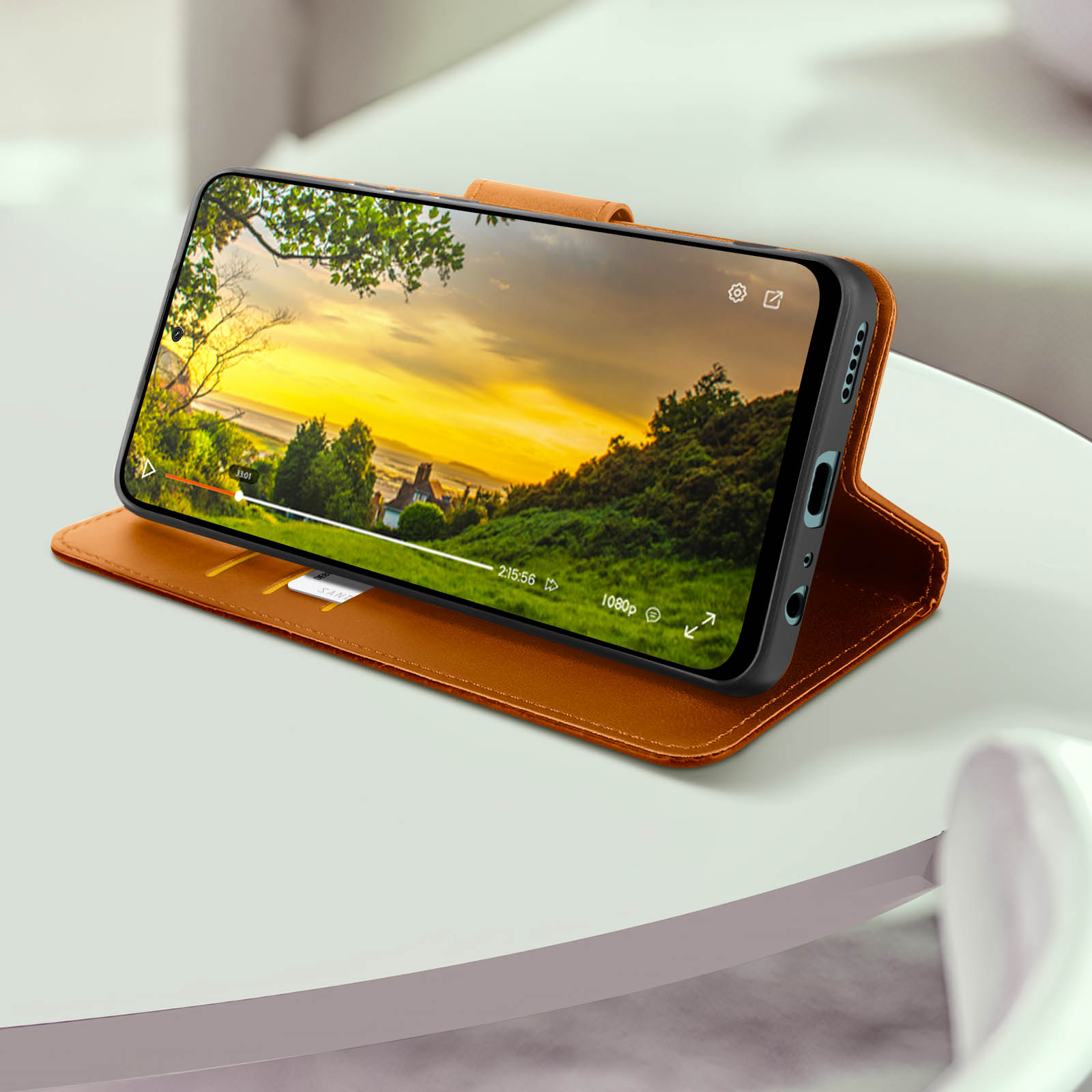 Smartphone in una custodia a portafoglio marrone che mostra un video.