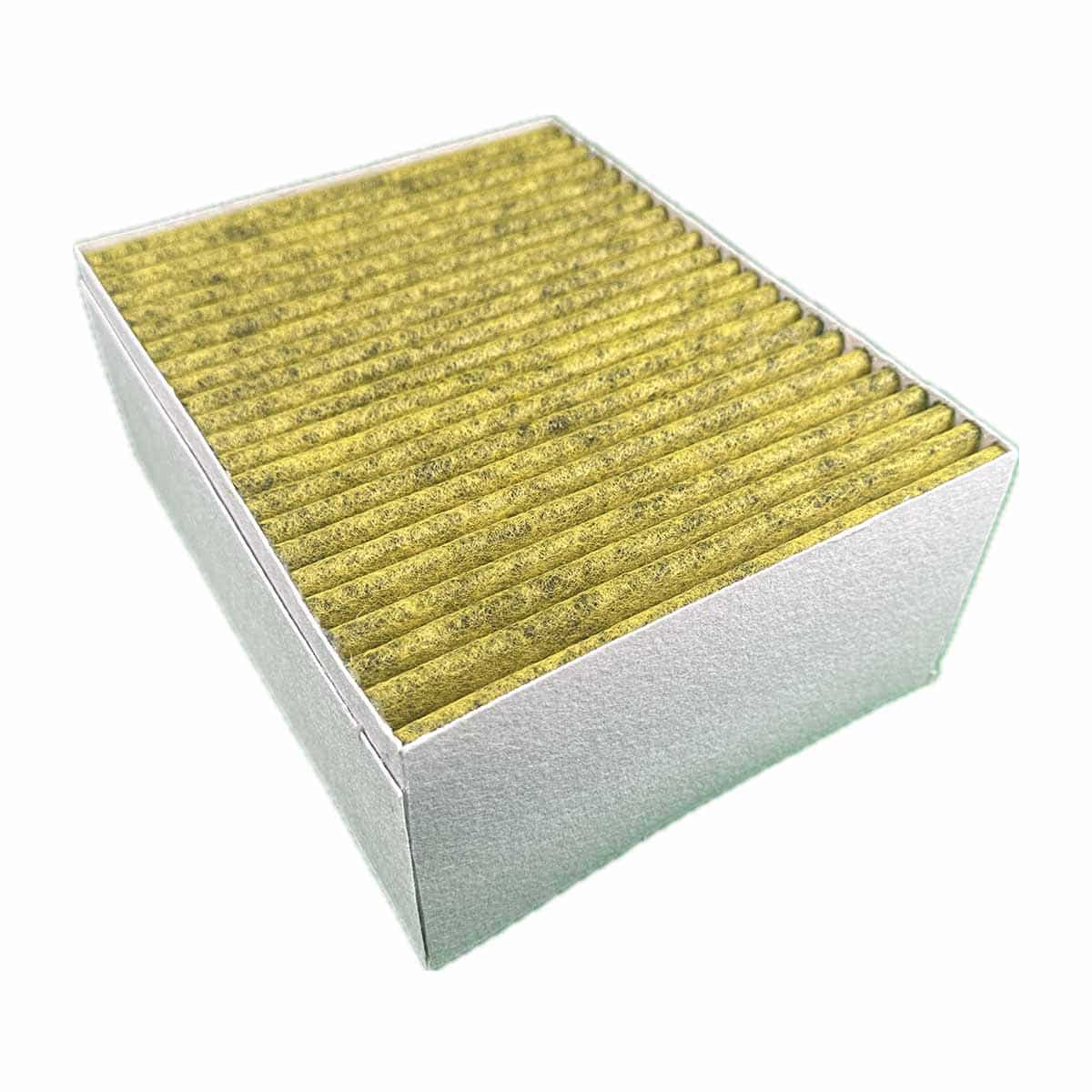 Ein rechteckiger Luftfilter in einem silbernen Rahmen, mit gelbem Filtermaterial. Der Filter ist angewinkelt.