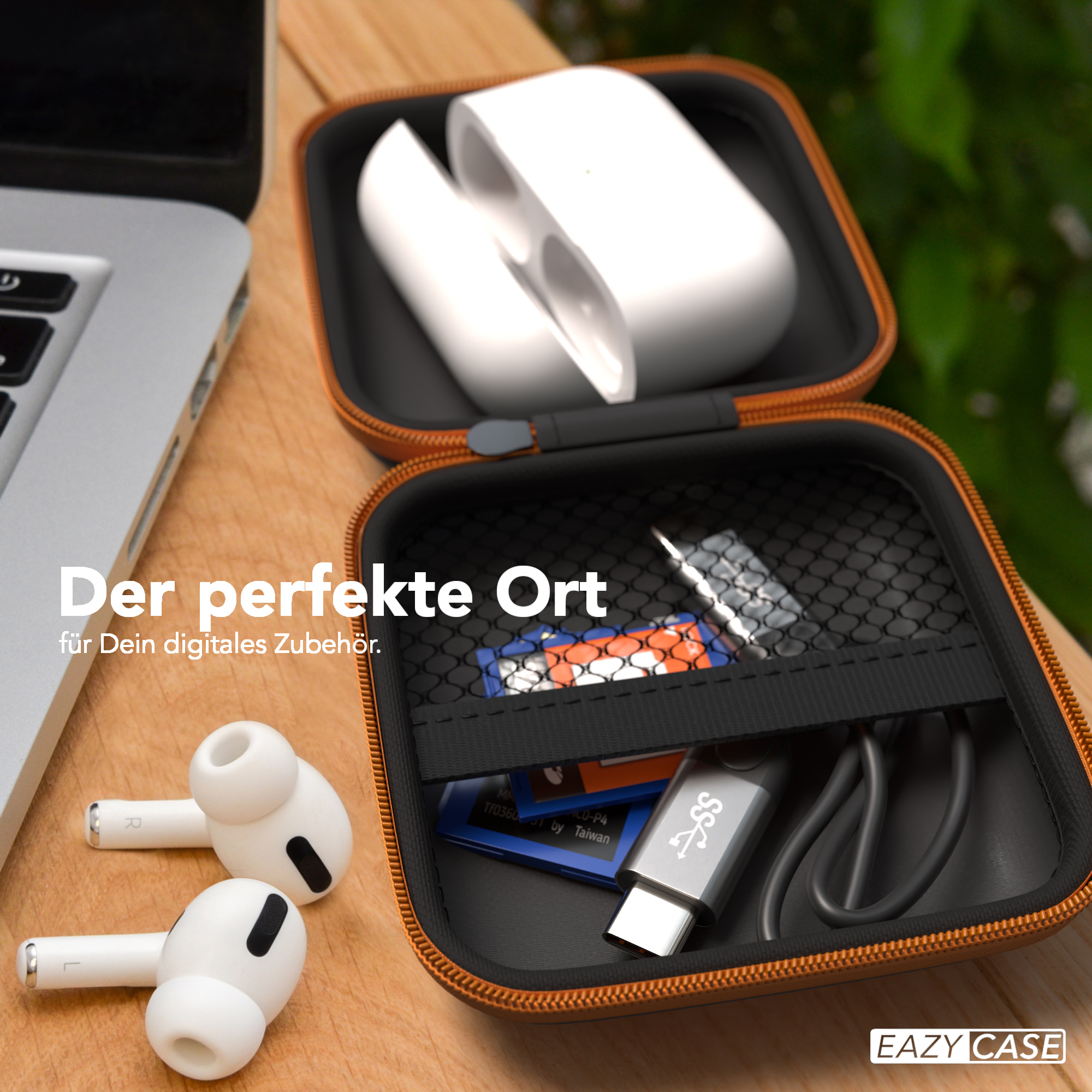 Etui mit Ohrhörern, Ladekabel und Speicherkarten, präsentiert auf einem Holztisch, und ein Laptop.