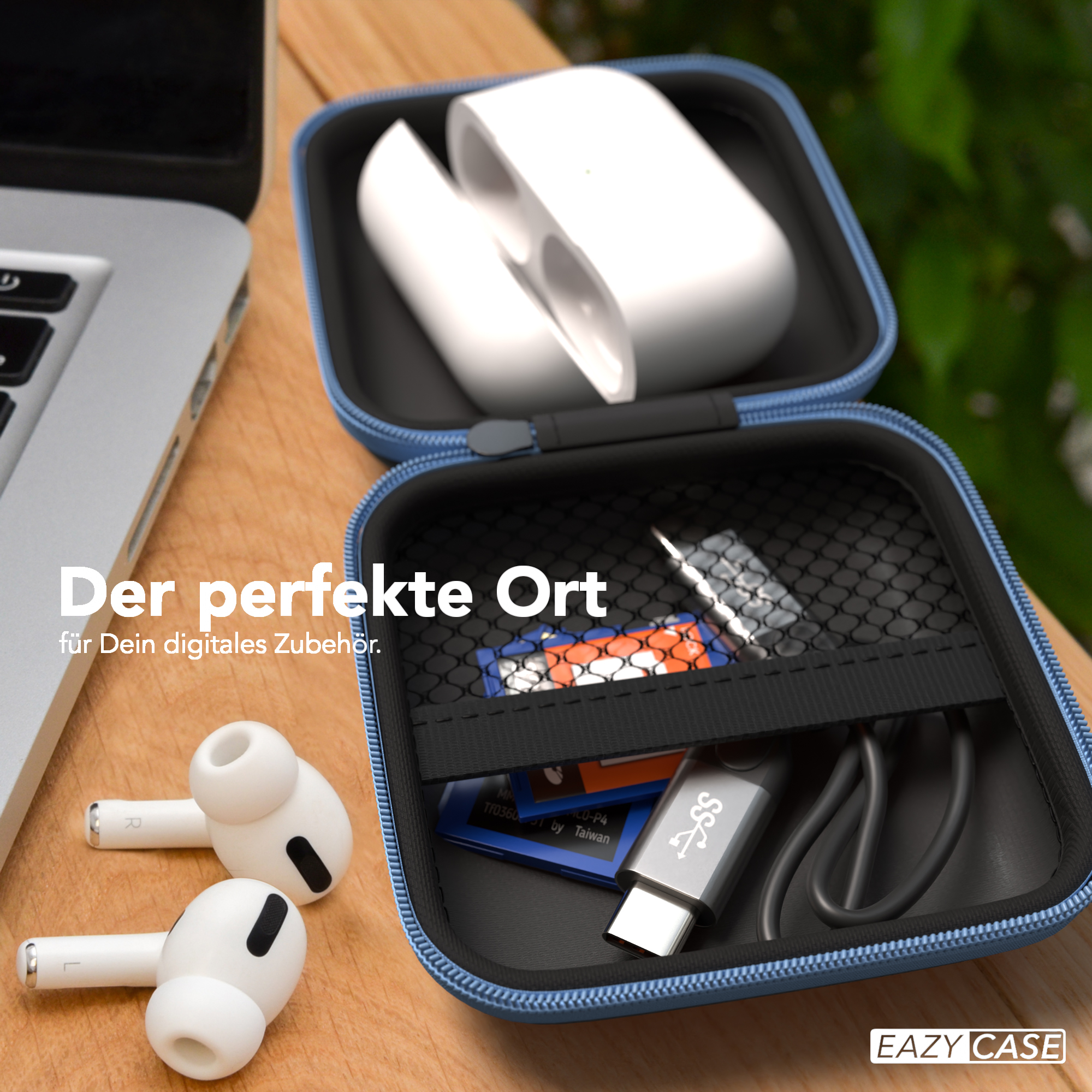 Geöffnete Hülle mit AirPods, USB-C-Kabel, SD-Karte und anderem Zubehör auf Holztisch.