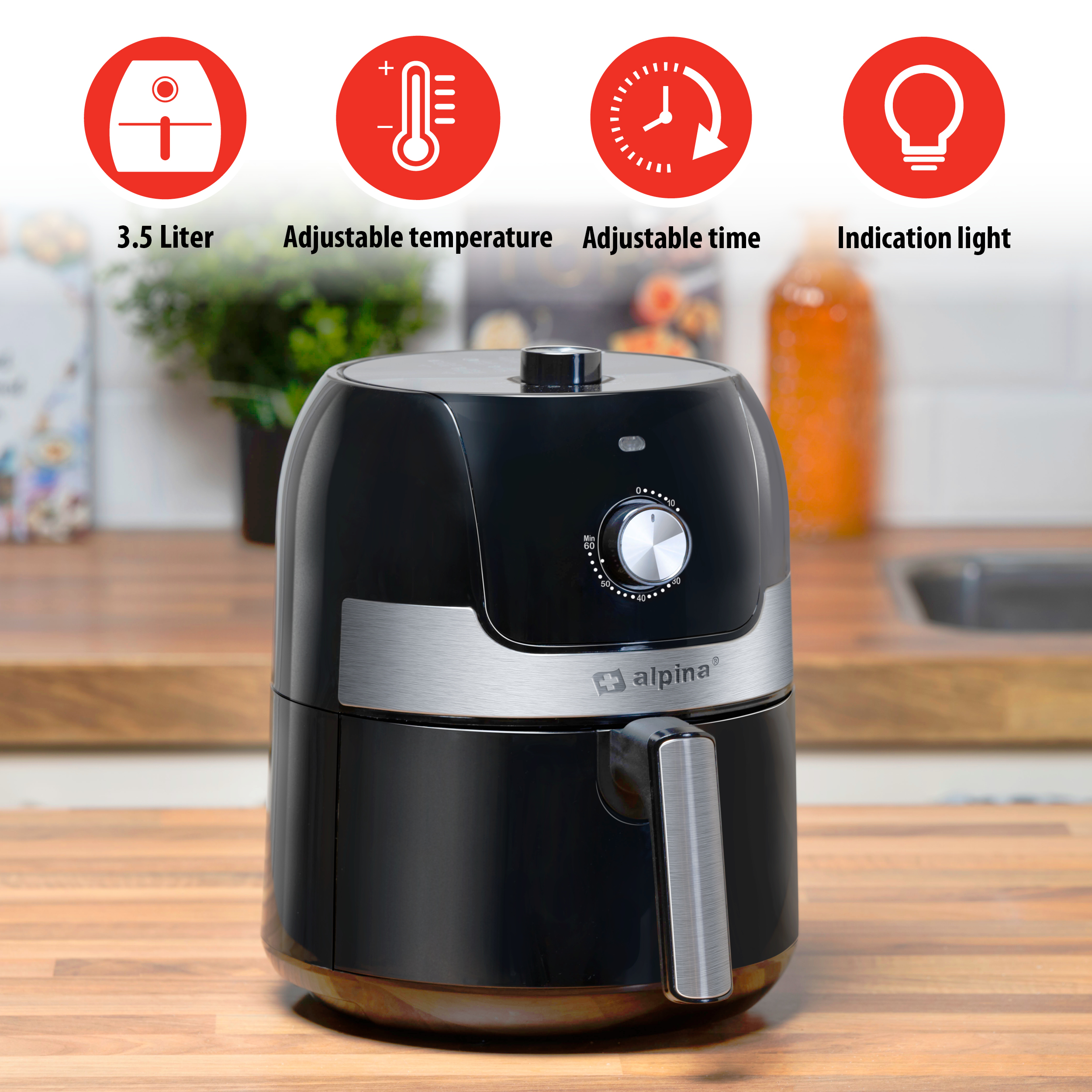 Zwarte airfryer met iconen, op een houten aanrecht.