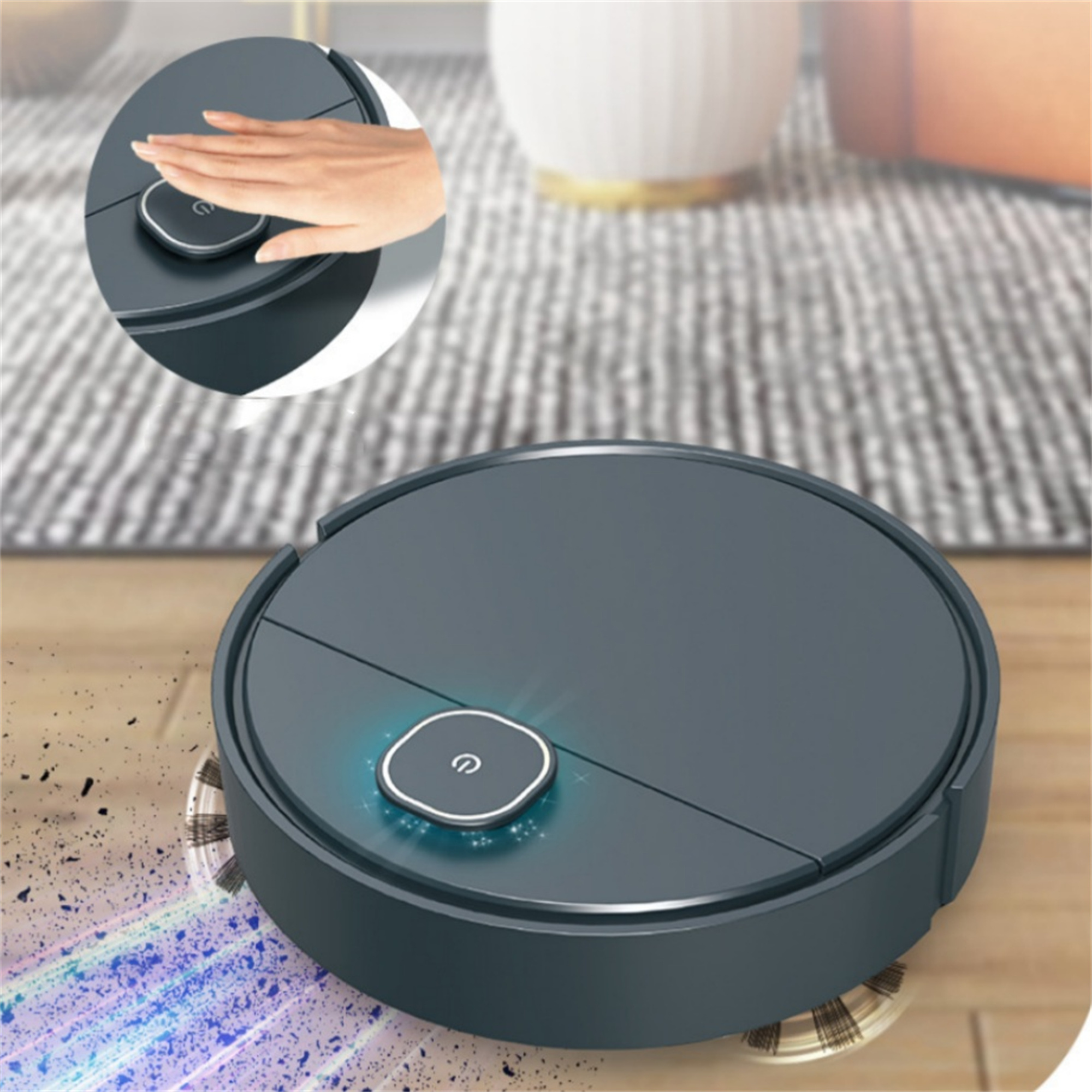 Runder, dunkelgrauer Roboter-Staubsauger mit einer Hand, die den Ein-/Ausschalter auf einem Holzboden berührt.