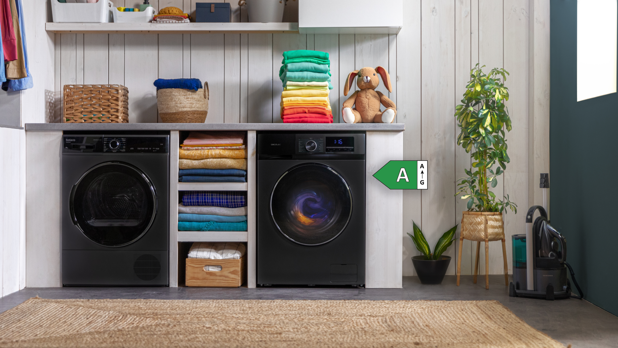 Pralnia z pralką, suszarką i stosem kolorowych ubrań.