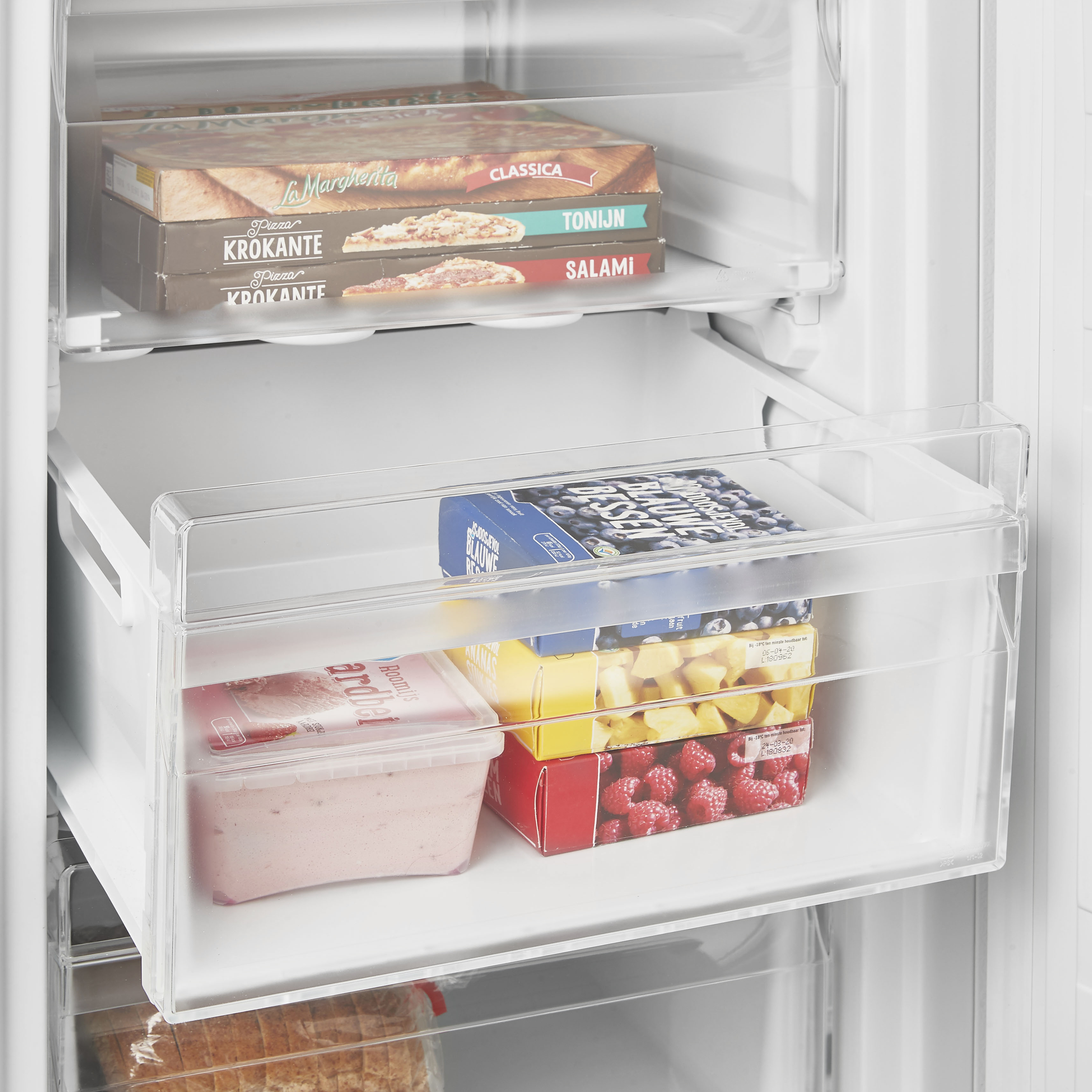 All'interno di un frigorifero, pizze surgelate e altri alimenti surgelati sono conservati nei cassetti.