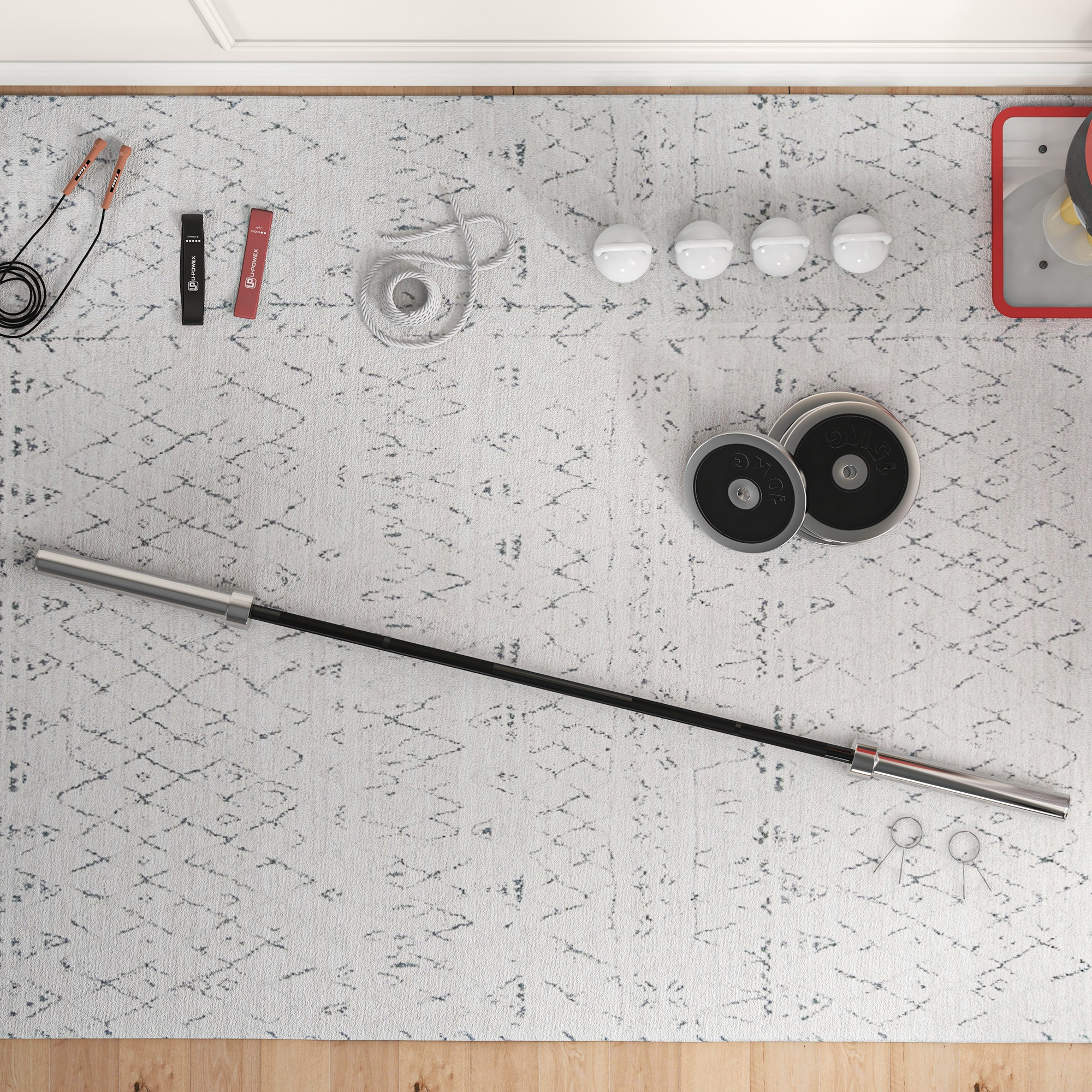 Una configuración de gimnasio en casa. Una barra, pesas, una cuerda para saltar y bandas de ejercicio sobre una alfombra gris.