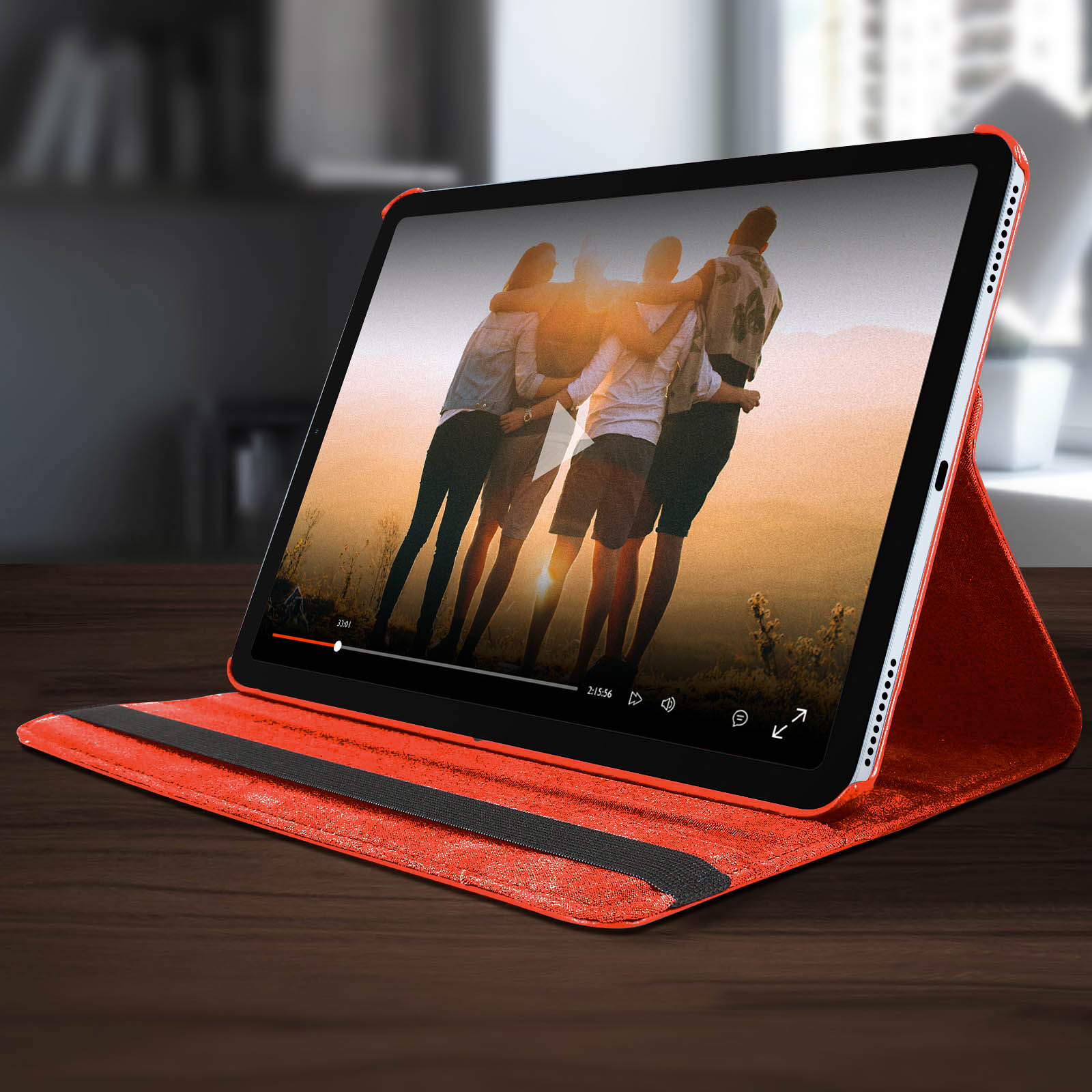 Tablet con video, in una custodia rossa, su una superficie.