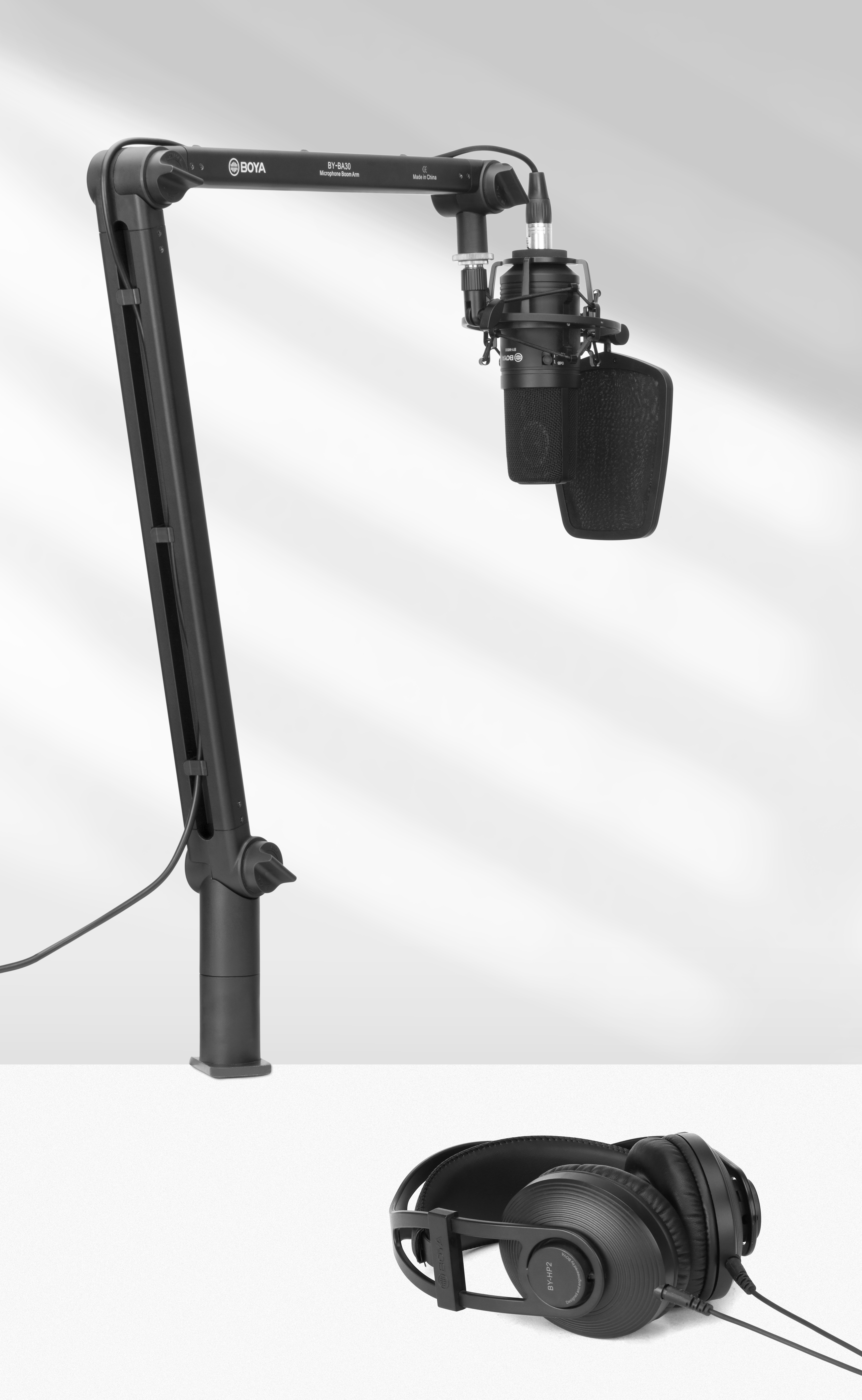 Micrófono y auriculares en un soporte. La configuración es negra sobre un fondo blanco.