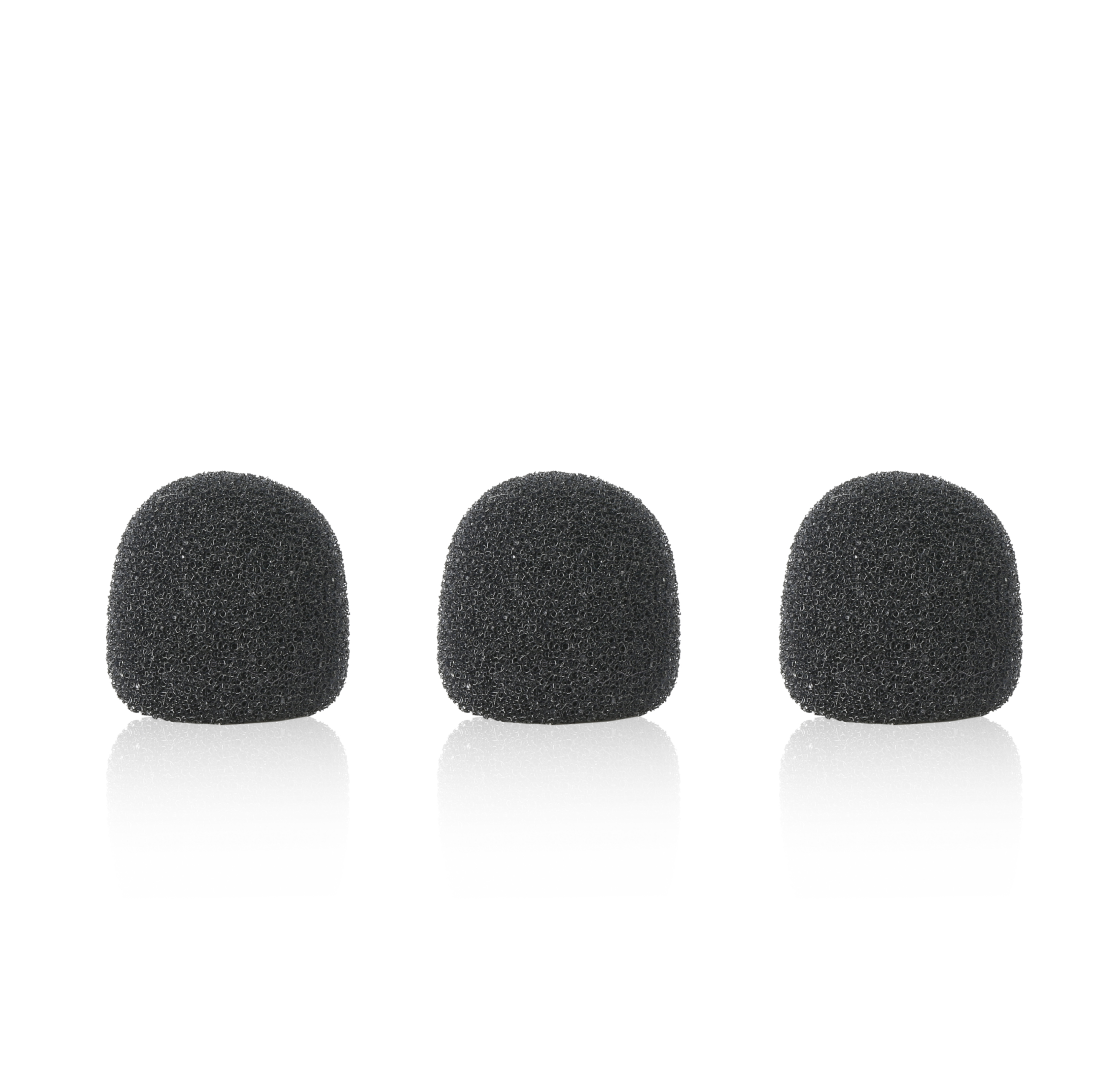 Tres cubiertas de espuma de micrófono negras dispuestas horizontalmente sobre una superficie blanca, con una ligera reflexión.