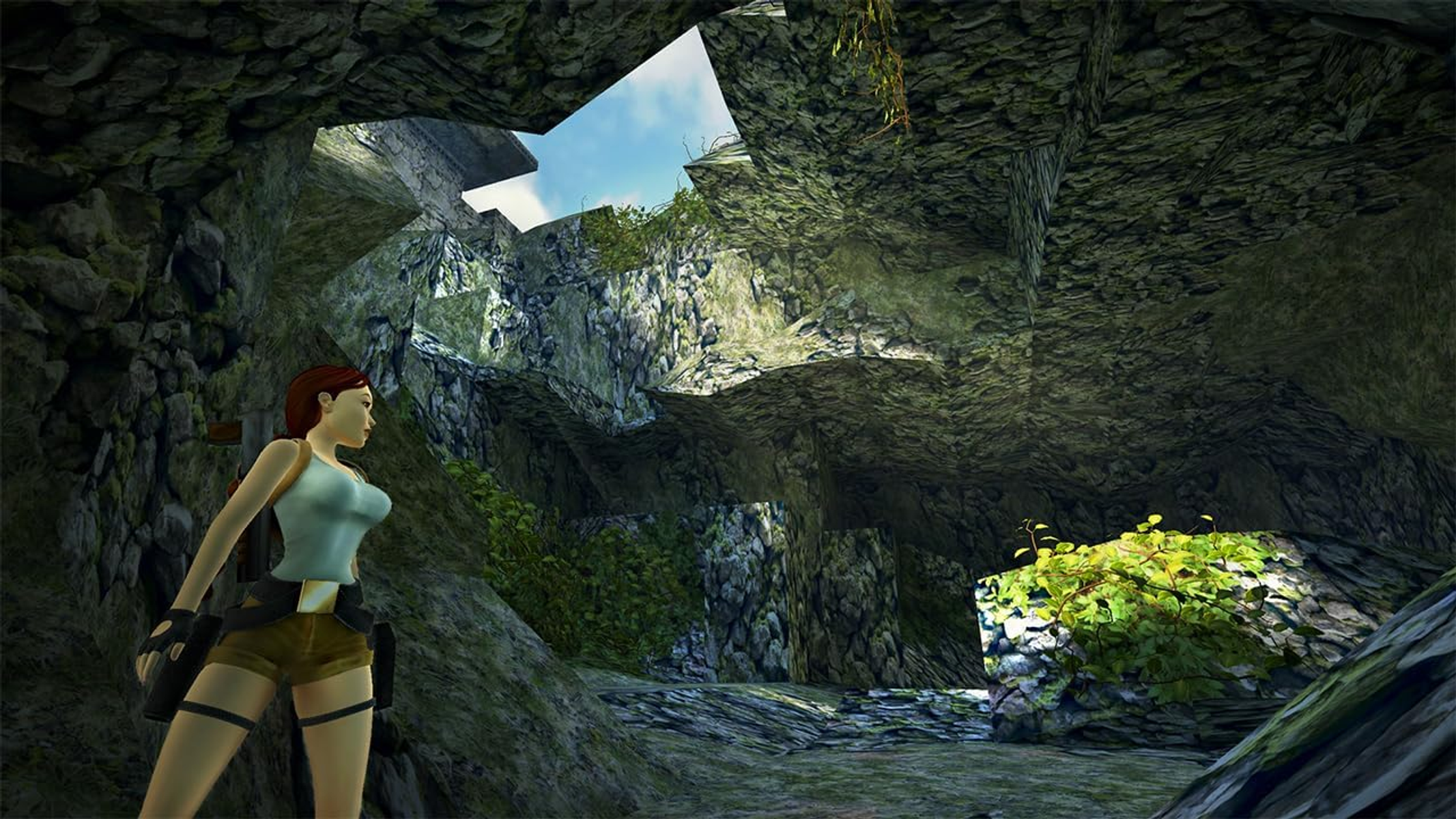 Lara Croft en una cueva, mirando a la derecha, con cielo azul visible.