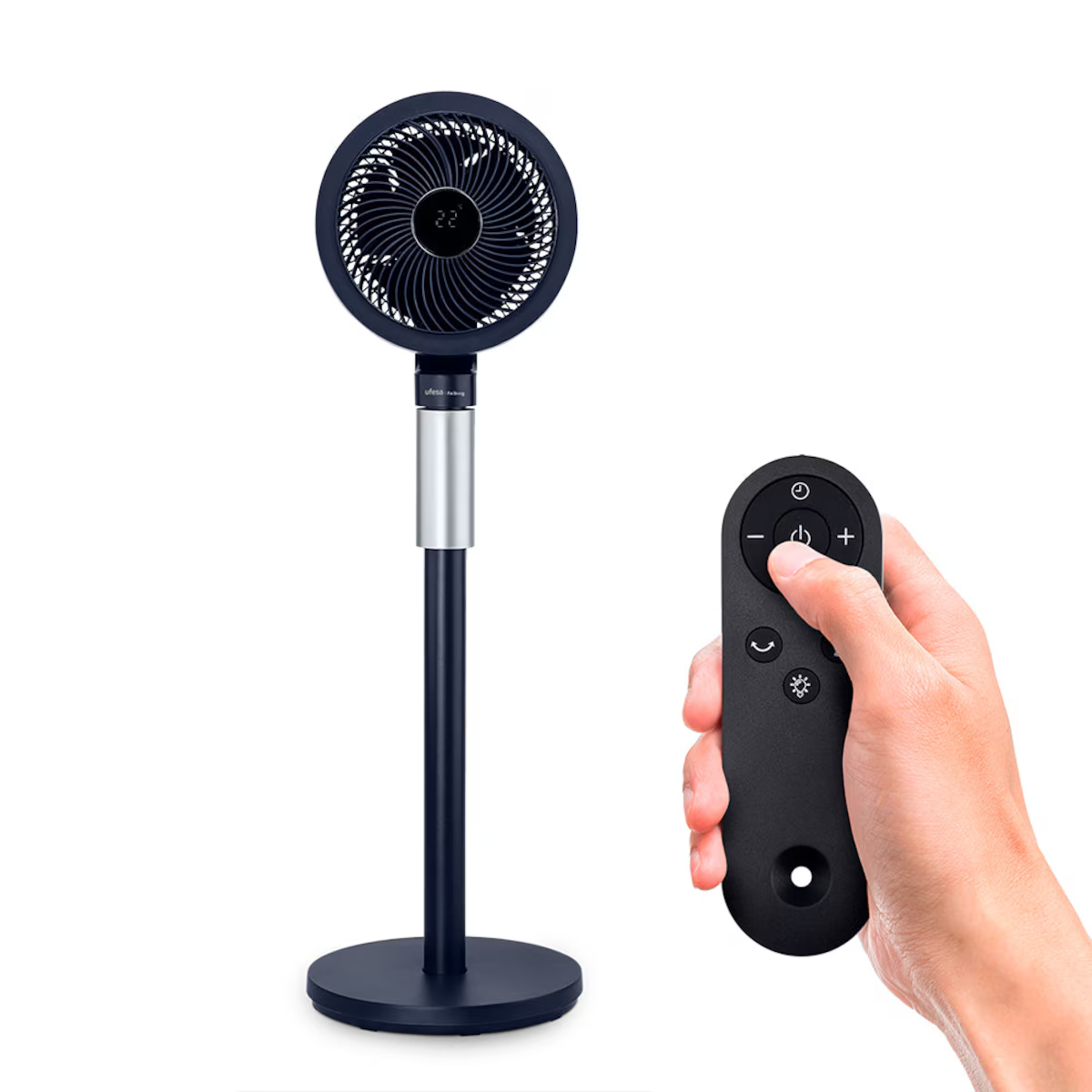 Un ventilatore a colonna nero e blu con un telecomando in mano a una persona, su sfondo bianco.