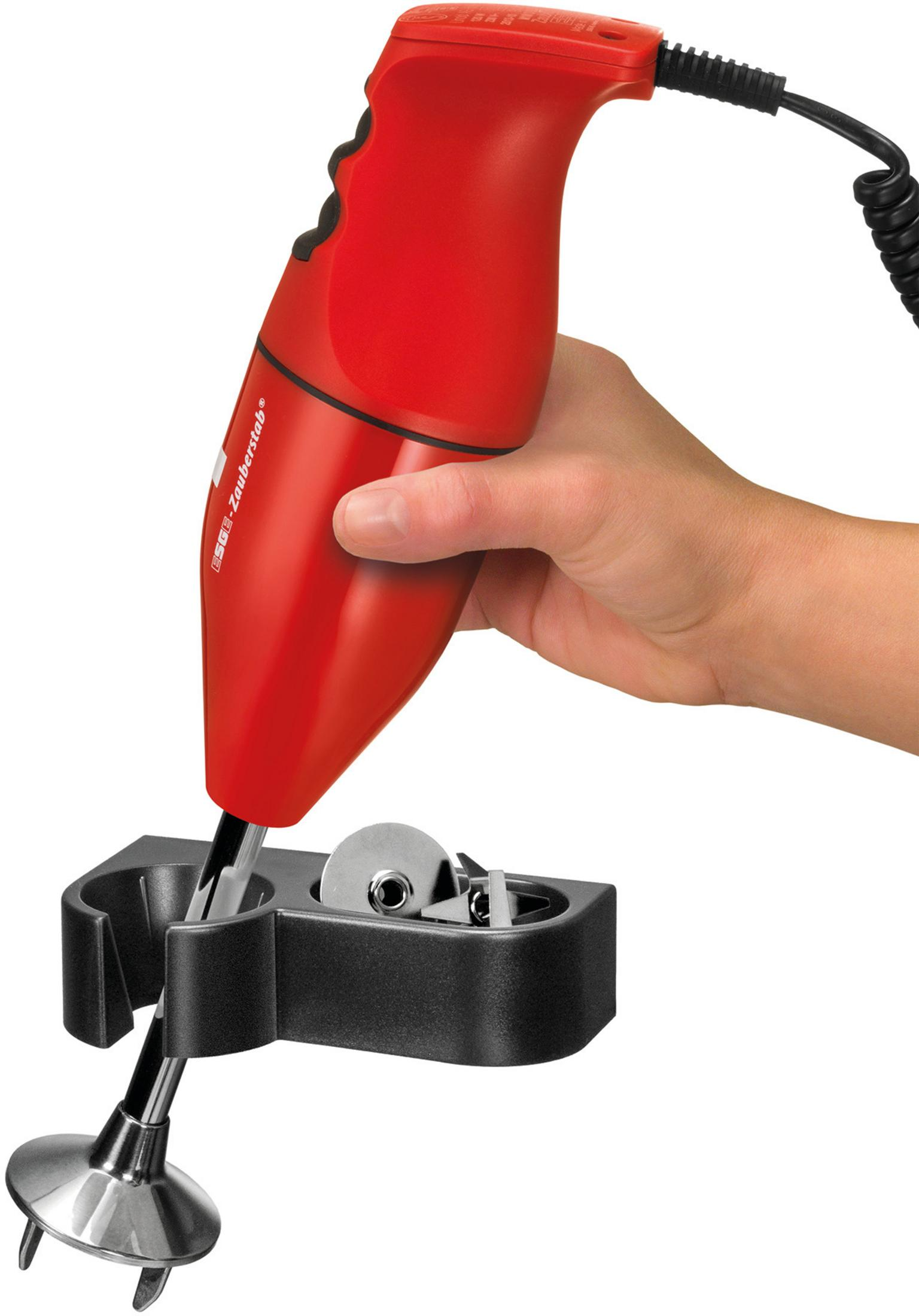 Czerwony blender ręczny z czarnym stojakiem i akcesoriami. Ręka trzyma blender.