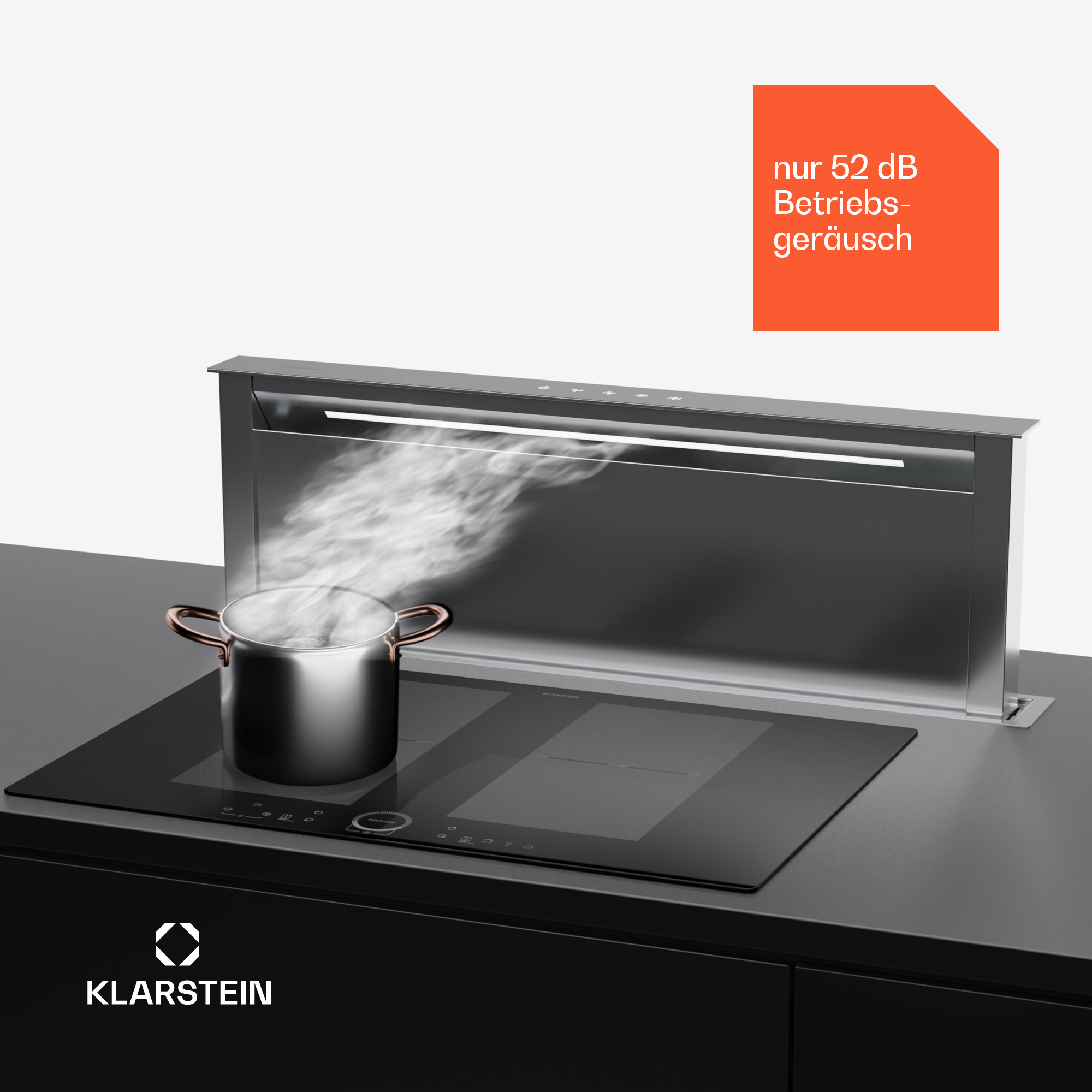 Una cucina moderna con piano cottura nero e cappa aspirante argentata, con vapore sopra una pentola.