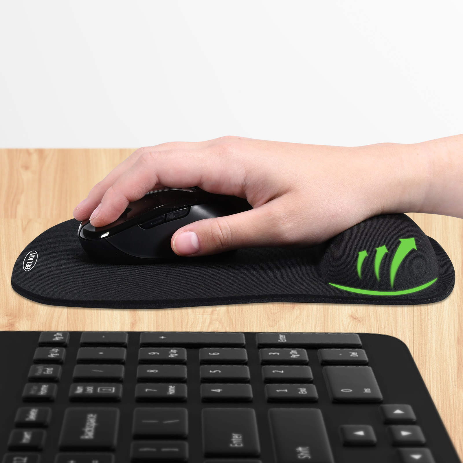 Hand benutzt schwarze Maus auf schwarzem Mauspad mit Handgelenkauflage, Tastatur im Vordergrund.