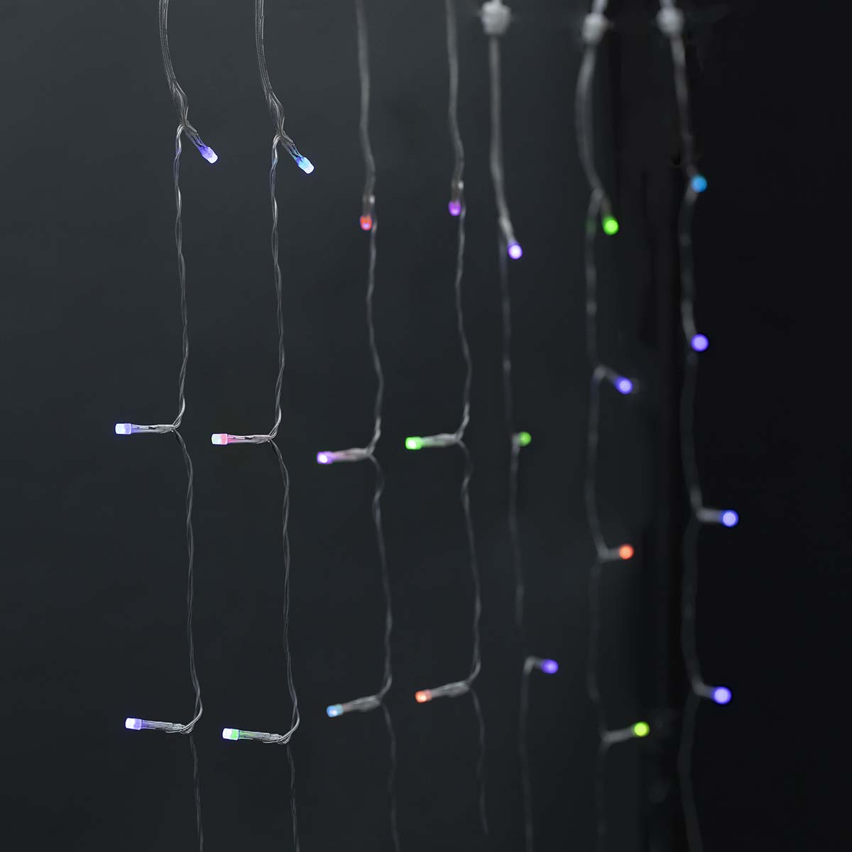 Światła sznurkowe z wieloma kolorowymi żarówkami LED na czarnym tle.