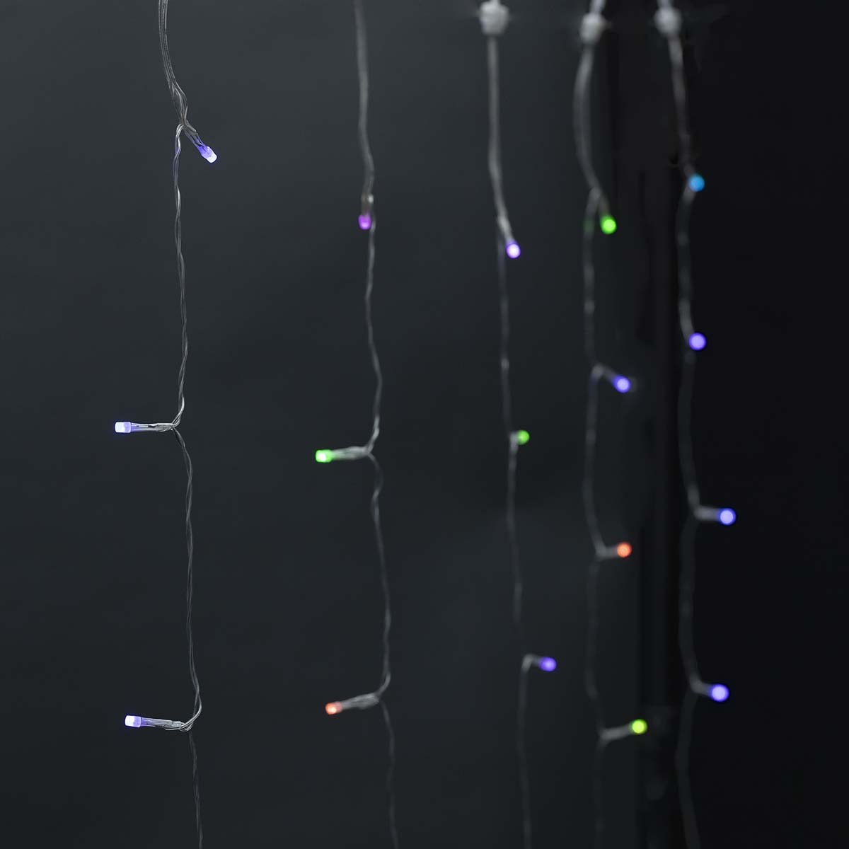 Szereg małych, kolorowych lampek LED na czarnym tle. Ostrość skupia się na światłach.