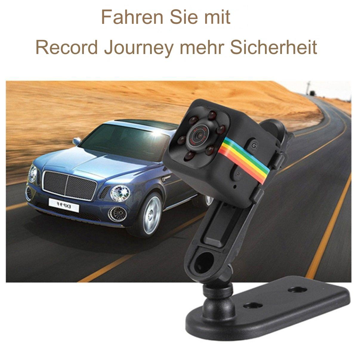 Eine kleine schwarze Dashcam mit mehrfarbigem Streifen, montiert an einem Auto, auf einer Straße.