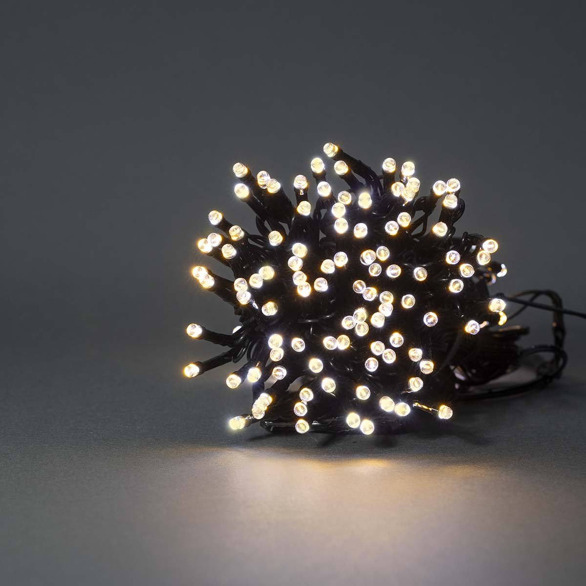 Een cluster van kleine, witte LED-lampjes op een donkergrijze achtergrond, die een heldere, warme gloed creëren.