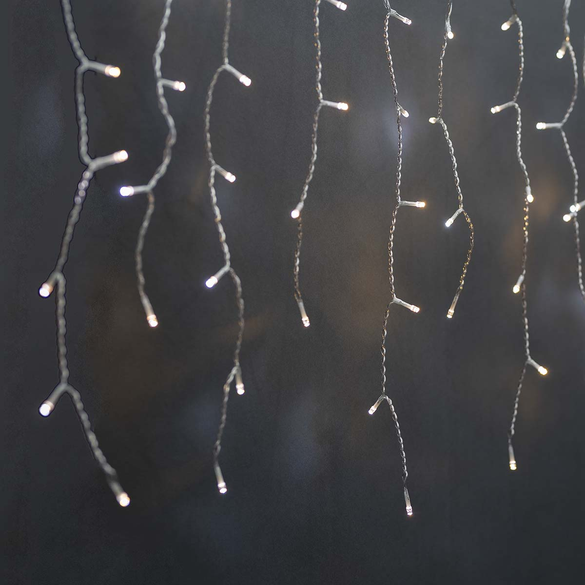 Kilka sznurów świateł zwisających w dół. Każde światło jest białe.