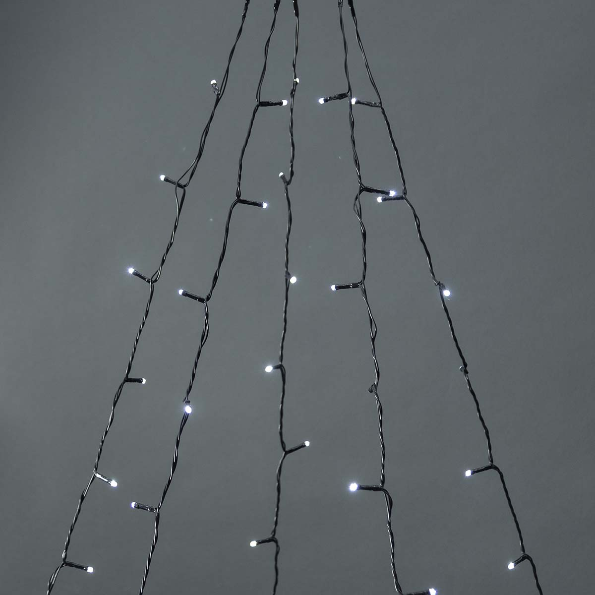Slinger van witte kerstverlichting hangend tegen een grijze achtergrond.