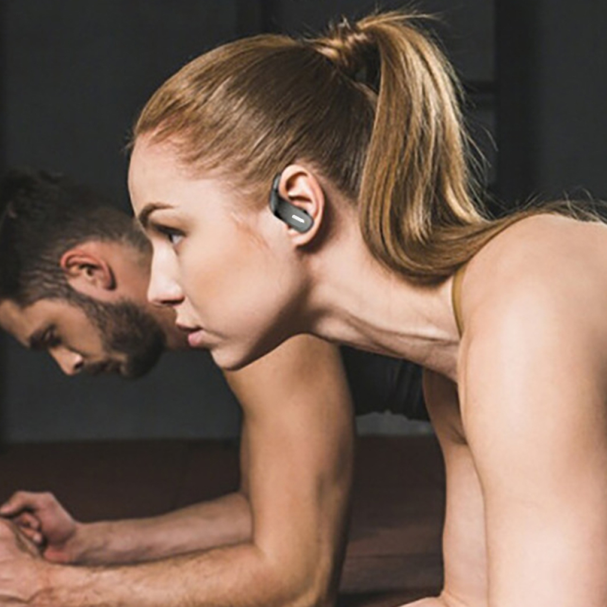 Zwei Personen in Sportkleidung, eine mit Ohrhörer. Fokus auf das Profil der Frau.