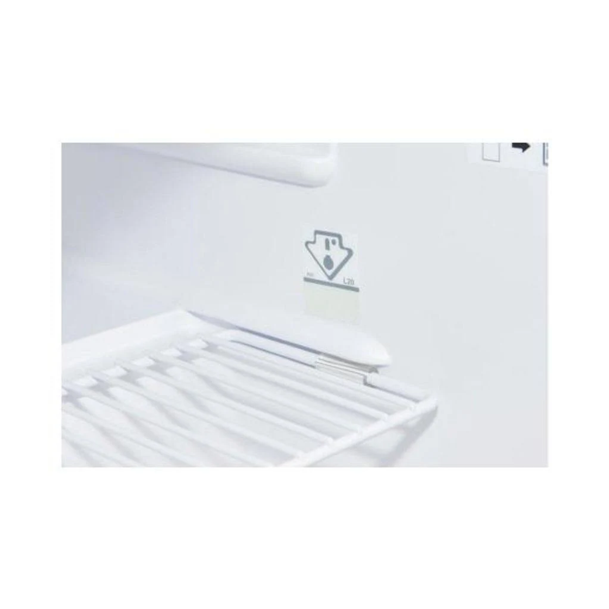 Interior de armario blanco con estante blanco y pegatina de símbolo de seguridad.