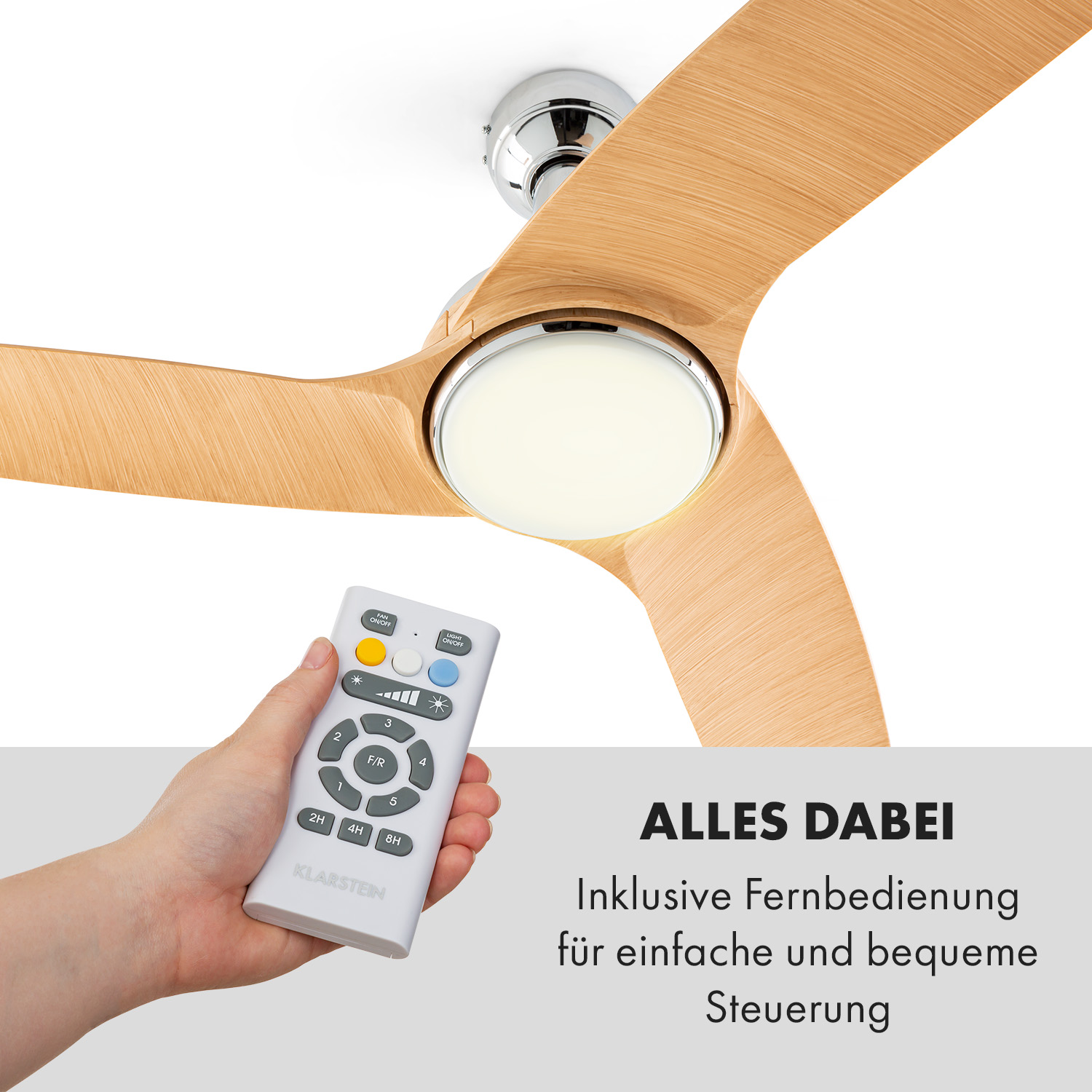 Mano che tiene un telecomando, ventilatore con luce e pale in legno, su sfondo bianco.