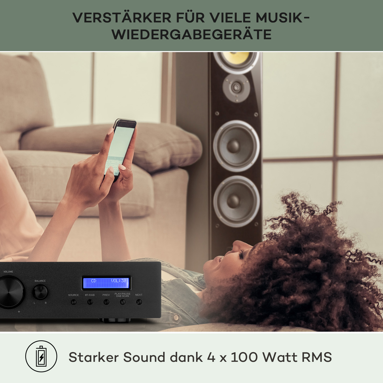 Eine liegende Frau hört Musik auf einem Telefon, das mit einem Soundsystem verbunden ist. Verstärker unten.