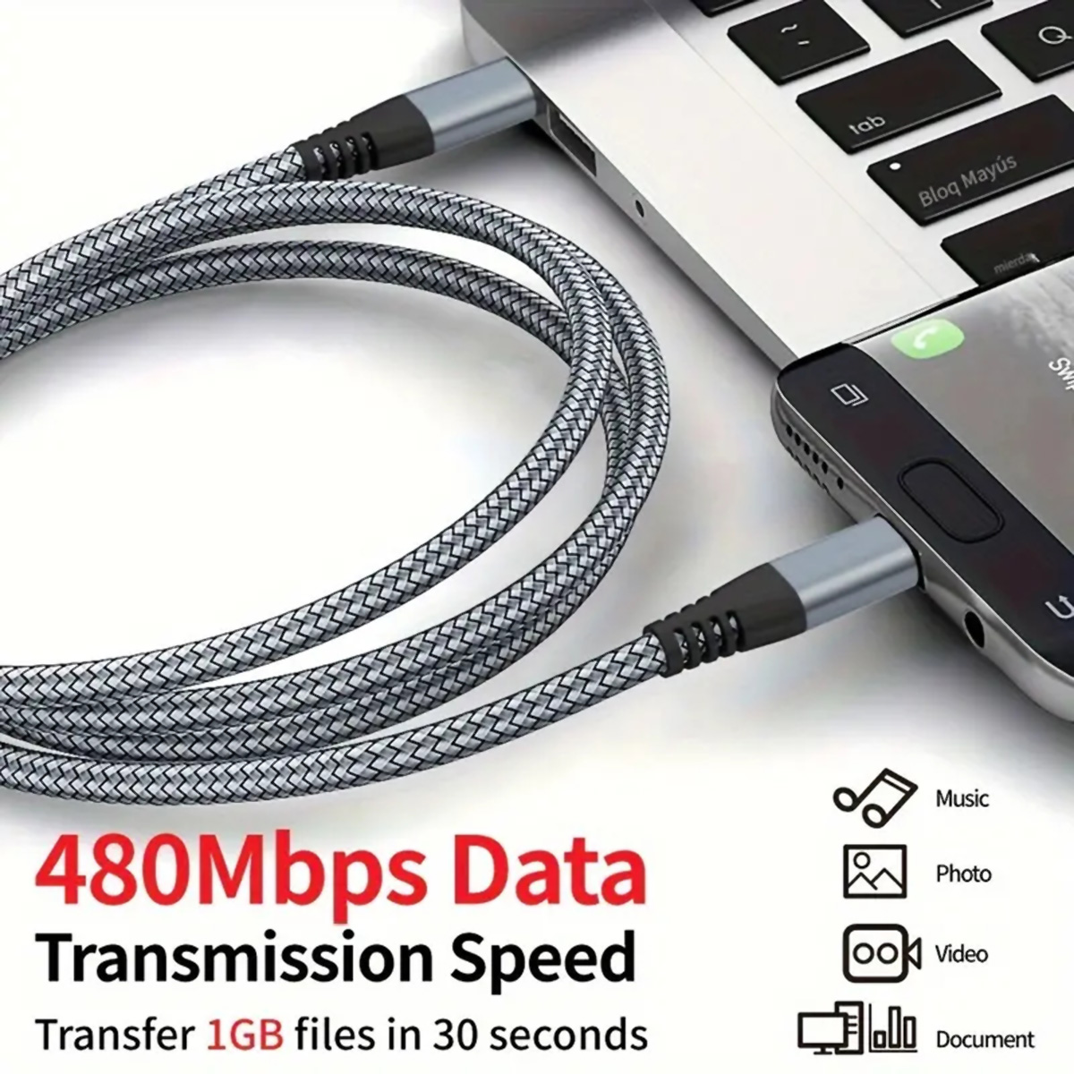 Un cable USB trenzado gris y negro conectado a una laptop y a un teléfono.