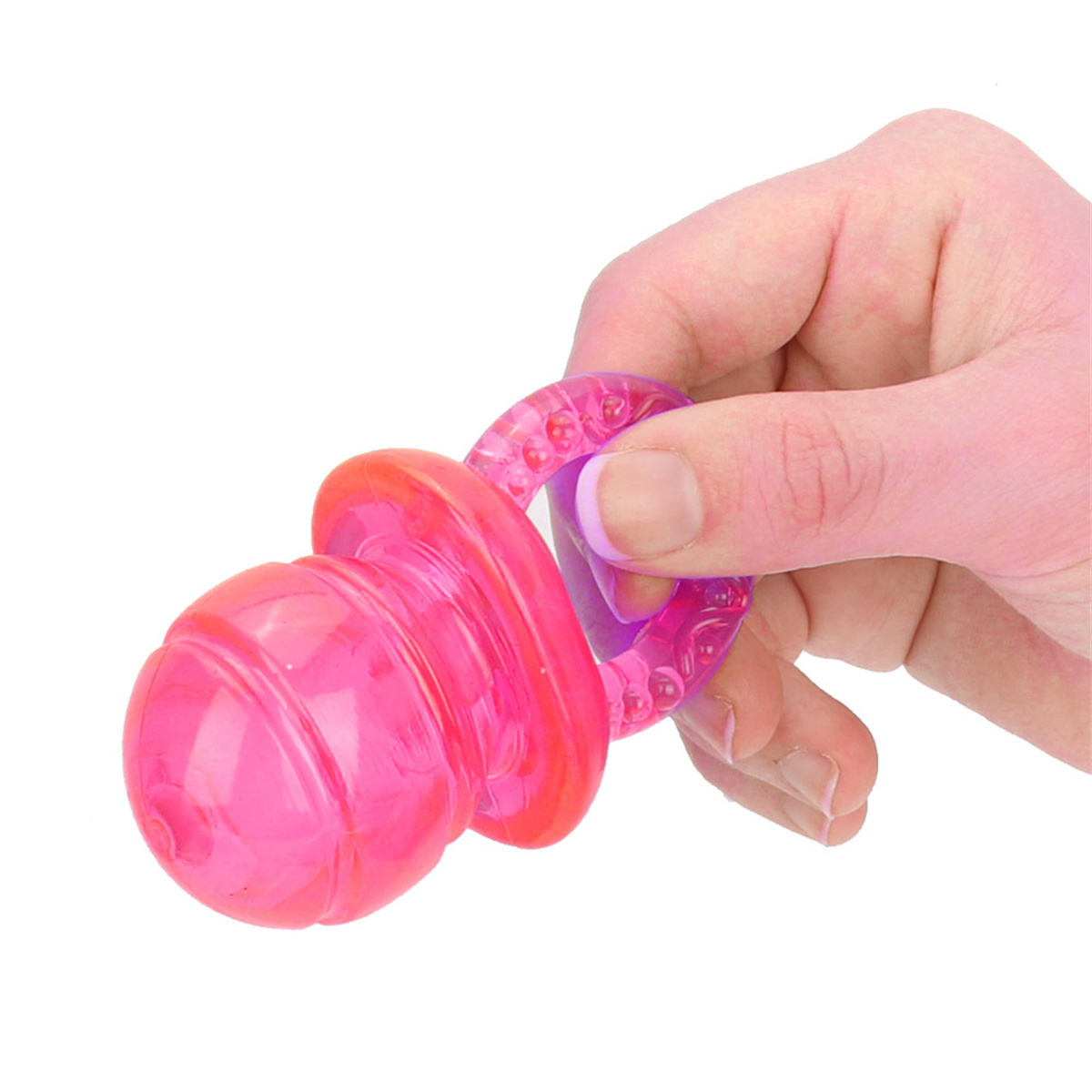 Hand hält ein rosa und lila Hundespielzeug. Es ist ein Beißspielzeug mit einem Ring.