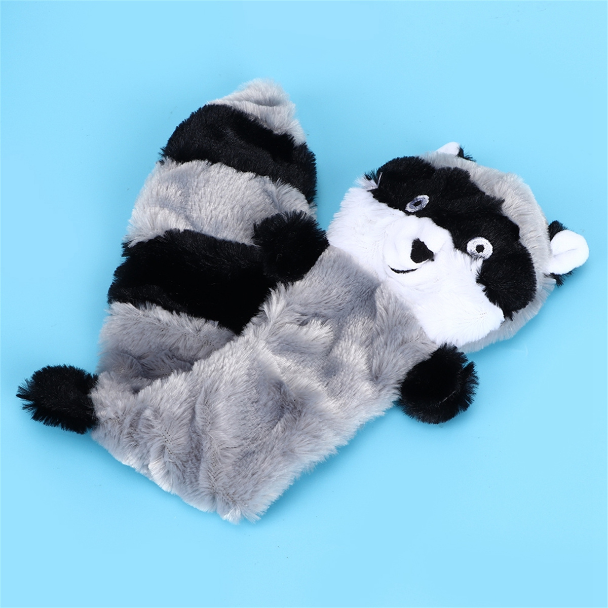 Ein Waschbär-Plüschtier mit schwarzen und grauen Streifen auf blauem Hintergrund.