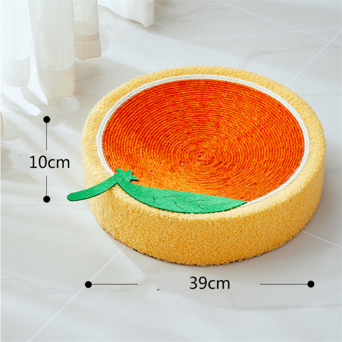 Orangefarbenes Katzenbett in Form einer Orangenscheibe, grünes Blatt befestigt.
