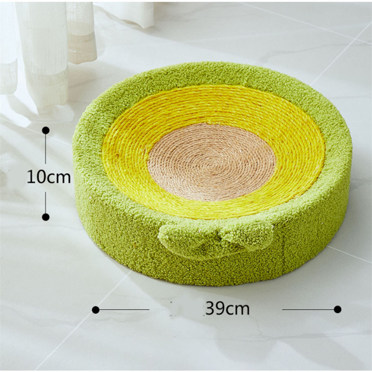 Ein grünes, avocado-förmiges Katzenbett mit Maßen auf einem weißen Fliesenboden.
