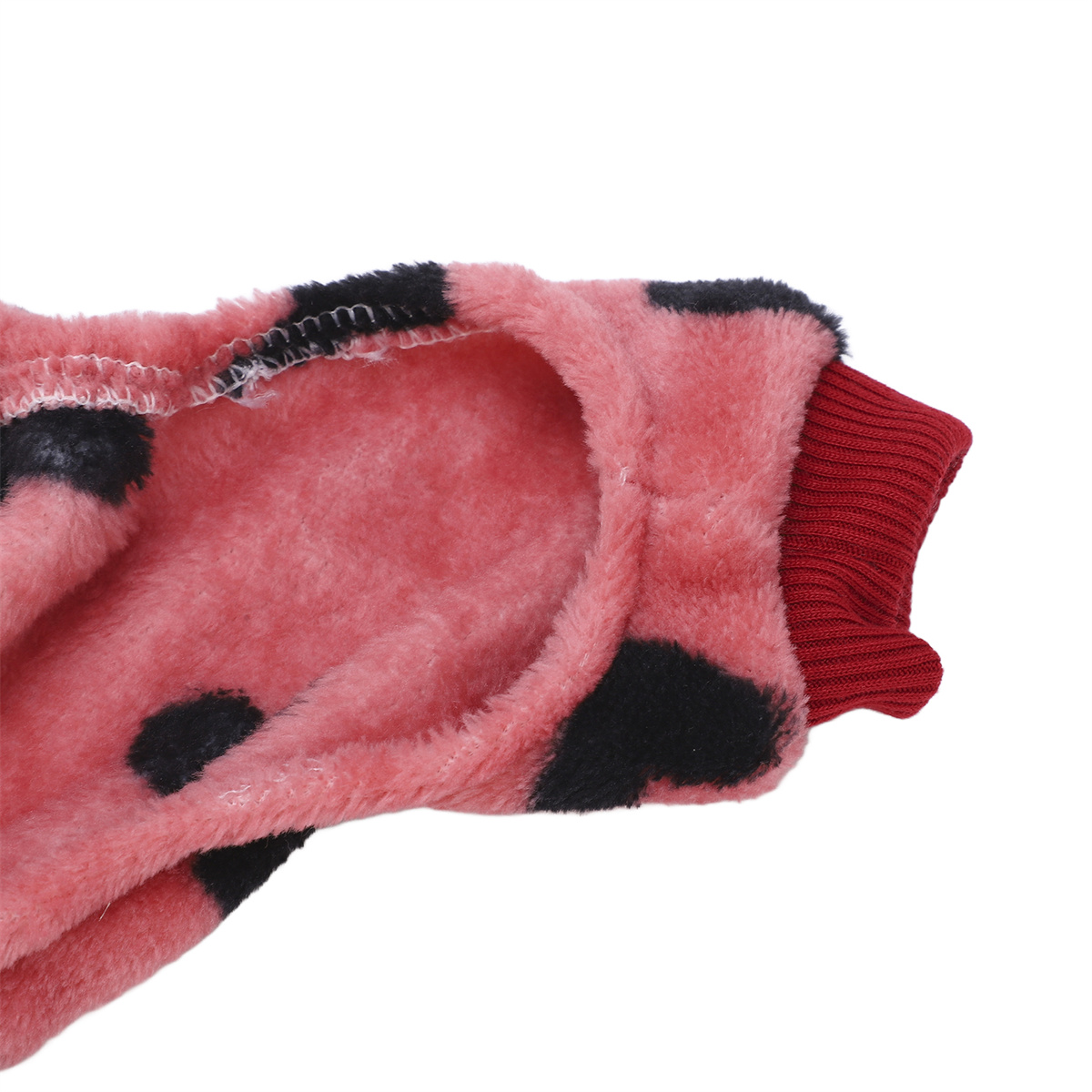 Nahaufnahme von rosa und schwarz gepunktetem Stoff. Roter Ärmelbund.