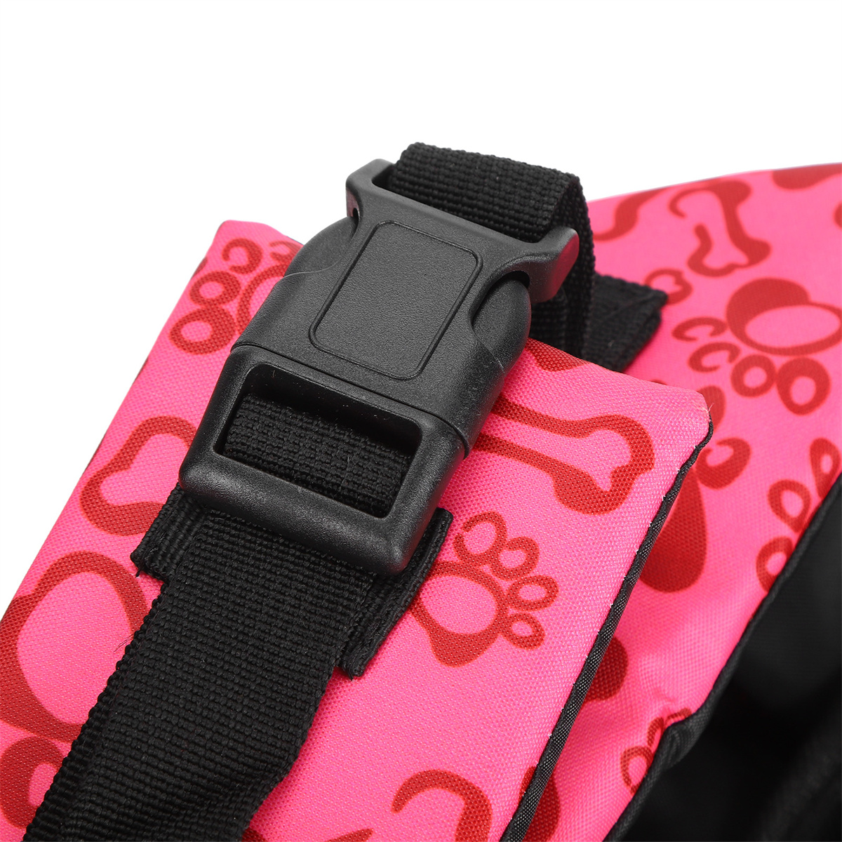 Nahaufnahme eines rosa Hunde-Geschirrs mit schwarzer Schnalle und Riemen. Pfotenabdruckmuster sichtbar.