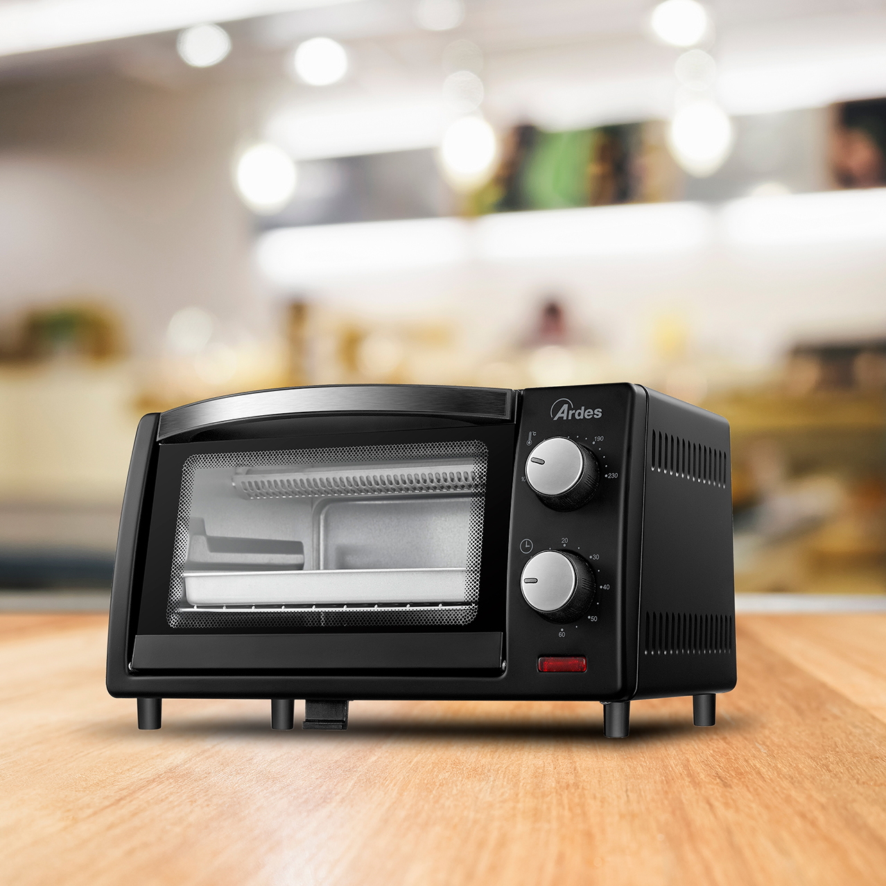 Un mini horno Ardes negro sobre una superficie de madera, con diales para temperatura y tiempo.