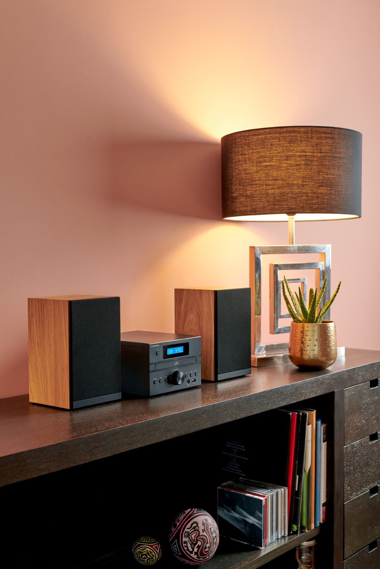 System stereo z głośnikami, odbiornikiem i lampą na drewnianej powierzchni.
