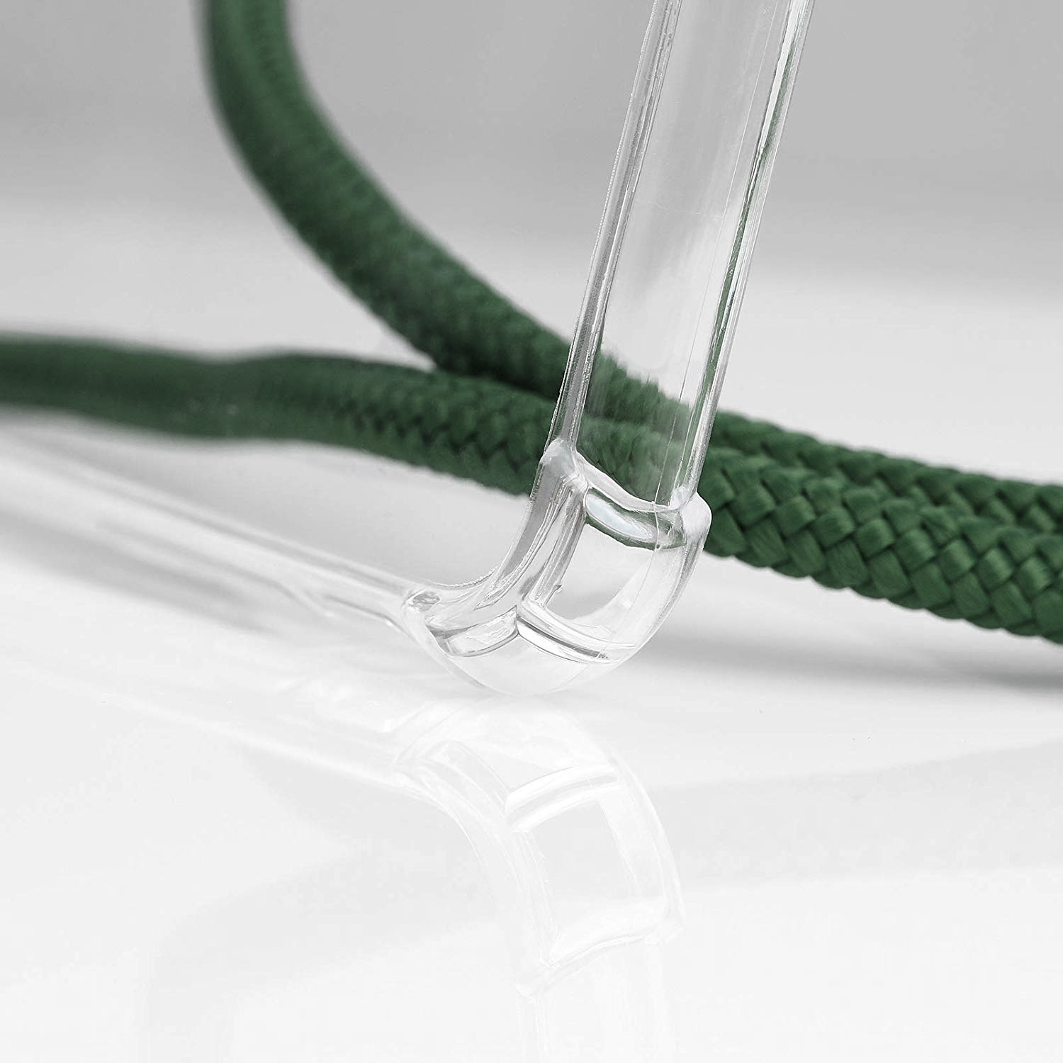 Primo piano di una custodia trasparente per telefono e una corda verde. La custodia curva attorno al telefono.