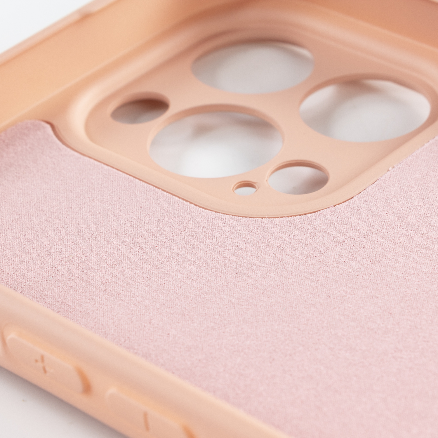 Interno della custodia del telefono color pesca, con fori. Tessuto rosa chiaro dentro.