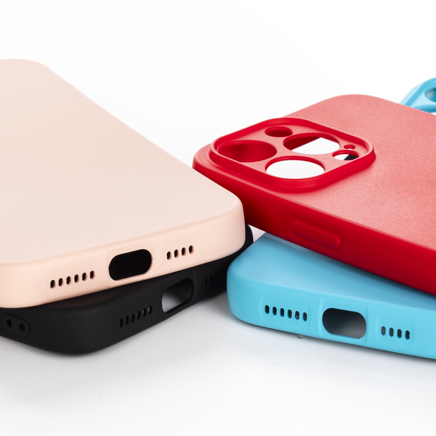 Primo piano di custodie per telefono rosa, rosse e blu. Una è sopra una custodia nera. Tutte hanno ritagli per le fotocamere.
