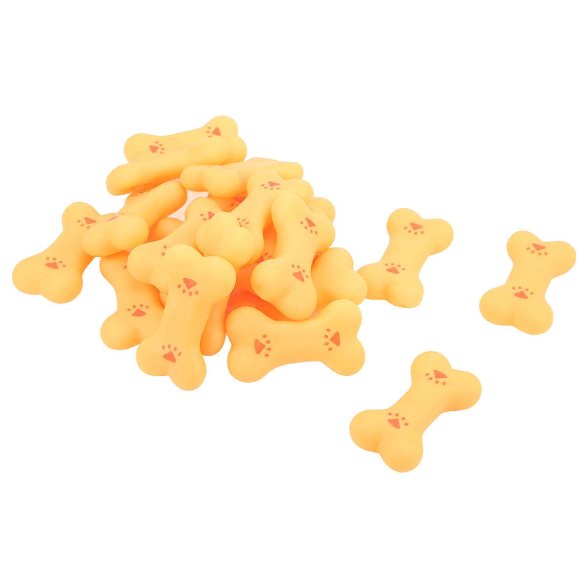 Gelbe Hundeleckerlis in Knochenform auf weißer Oberfläche verstreut.