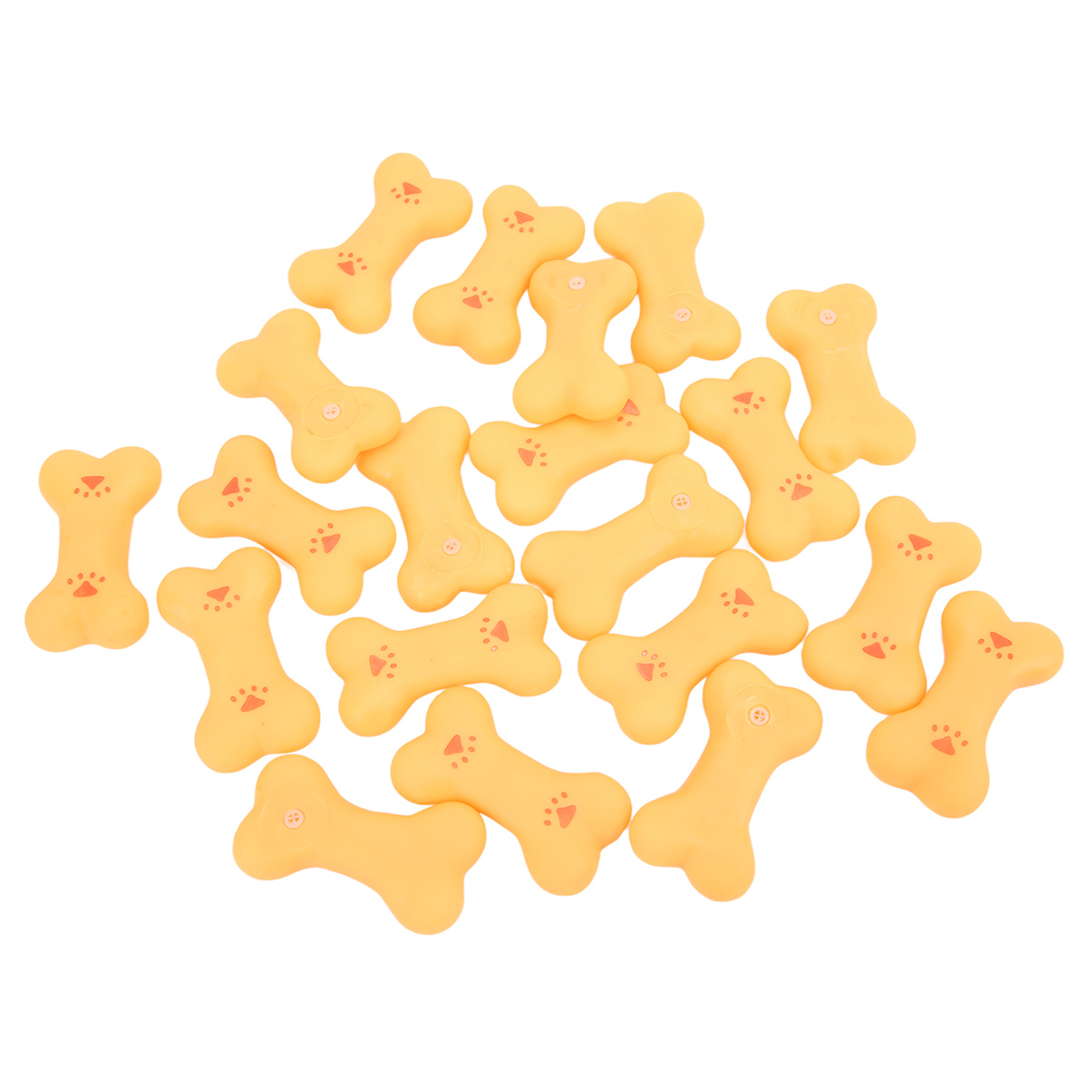 Verstreute gelbe Hundekekse in Knochenform auf einer weißen Oberfläche.