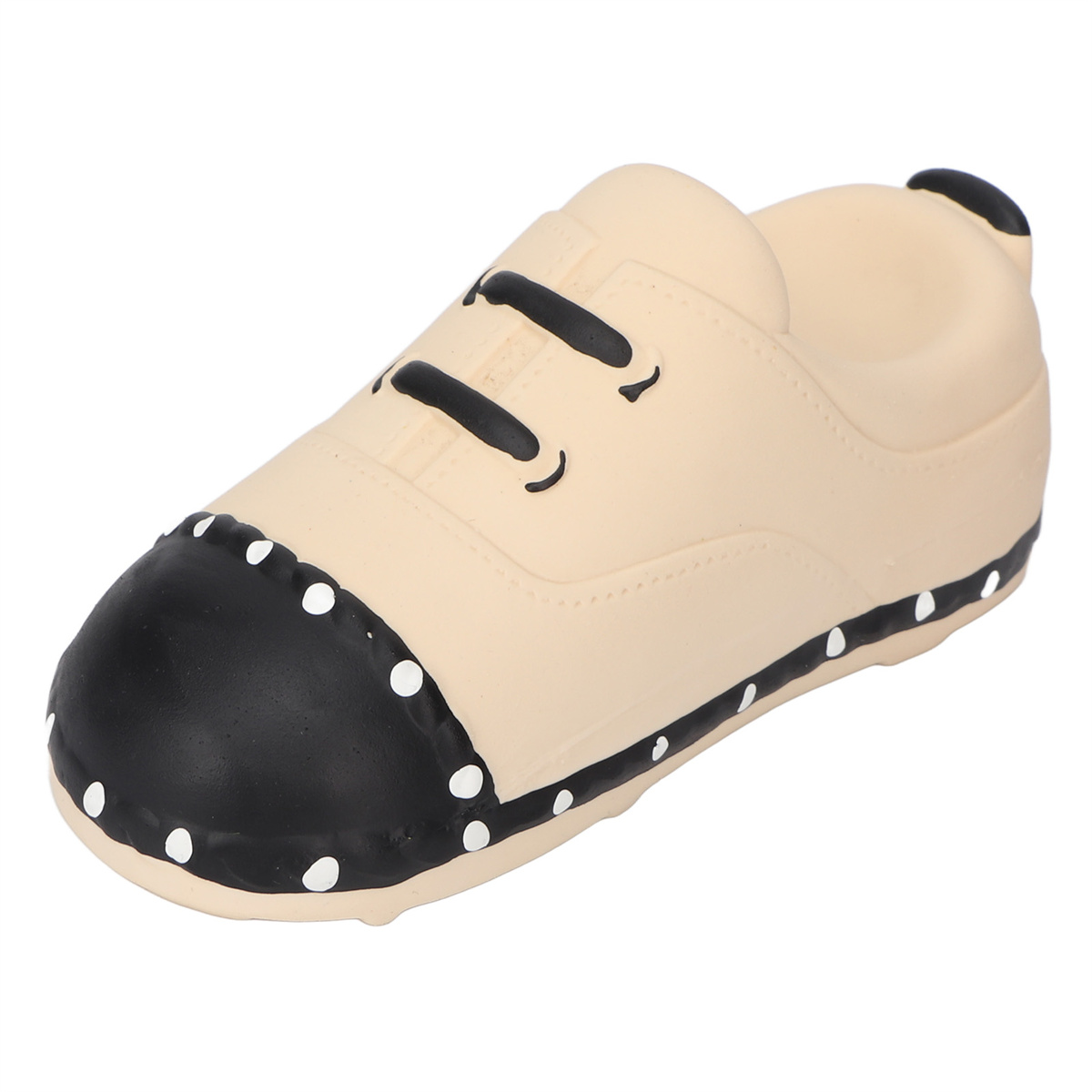 Spielzeugschuh in Beige, mit schwarzen Details und weißen Tupfen.