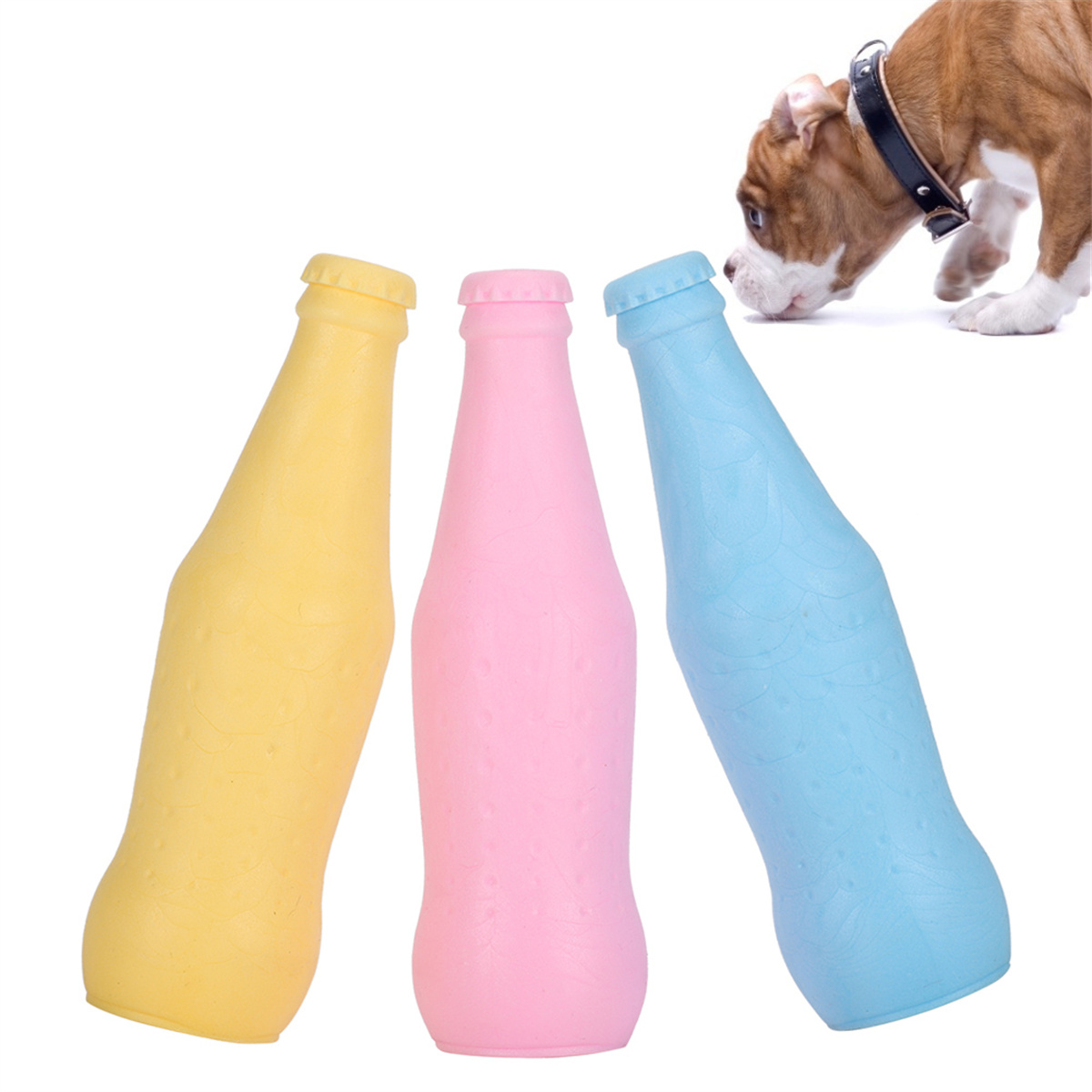 Drei bunte, flaschenförmige Hundespielzeuge: gelb, rosa und blau. Ein Hund schnuppert in der Nähe.
