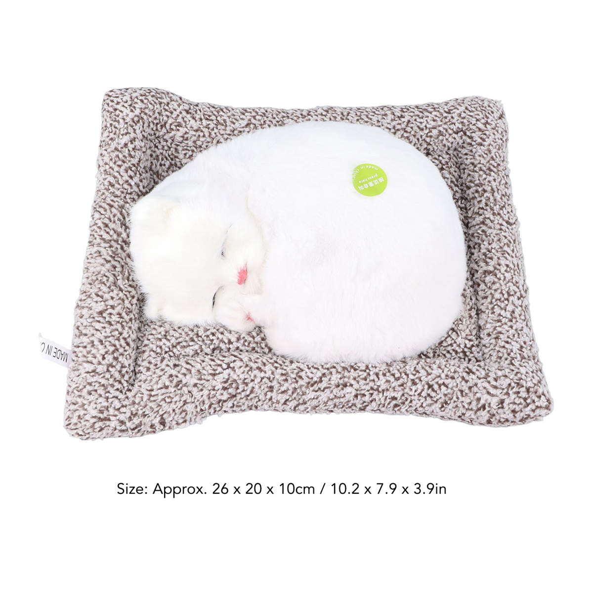 Ein weißes Katzenspielzeug auf einem braun-weißen Bett. Auf dem Bett steht "MADE IN C".