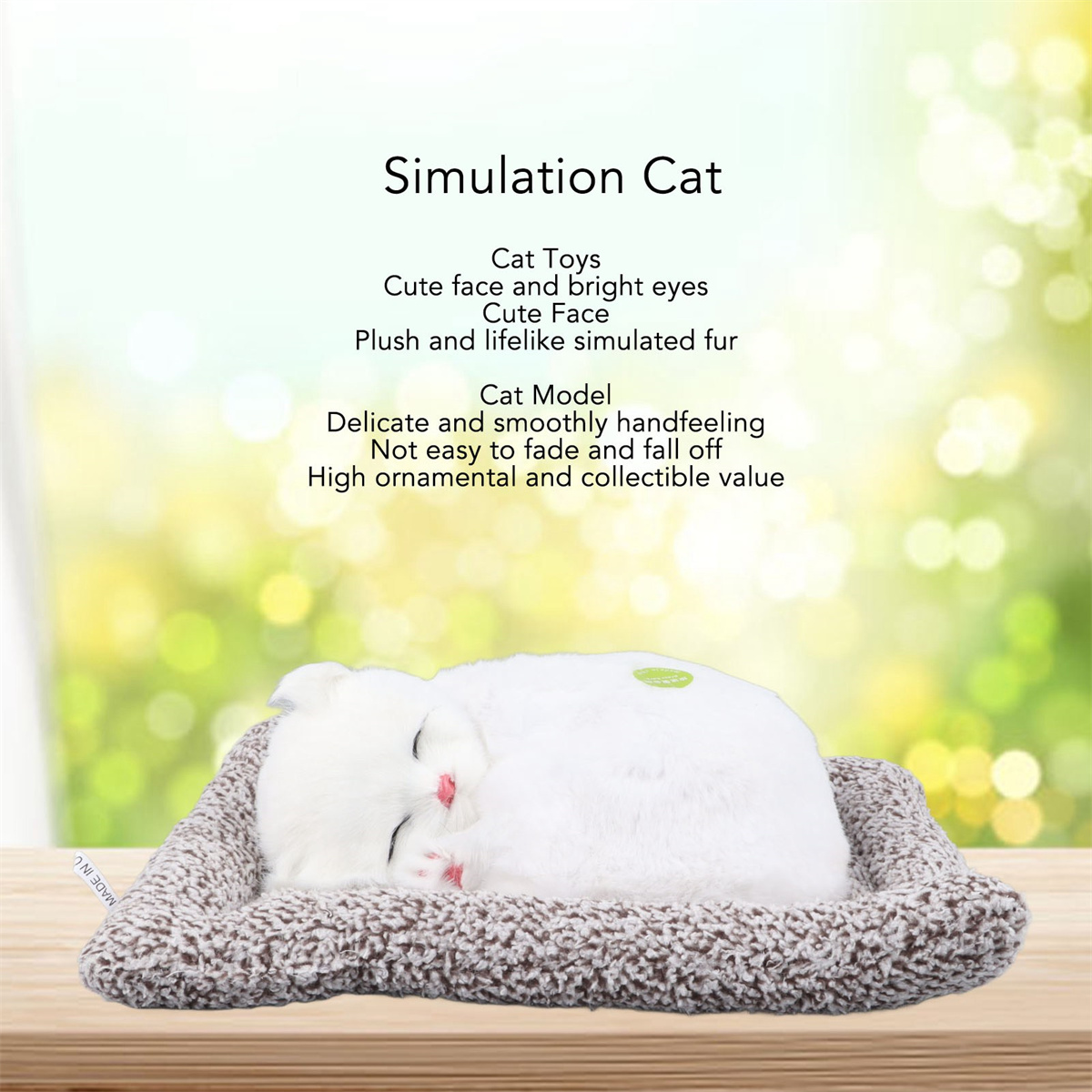 Weißes Katzenspielzeug auf einem Bett, mit Text über seine Eigenschaften, vor verschwommenem grünem Hintergrund.