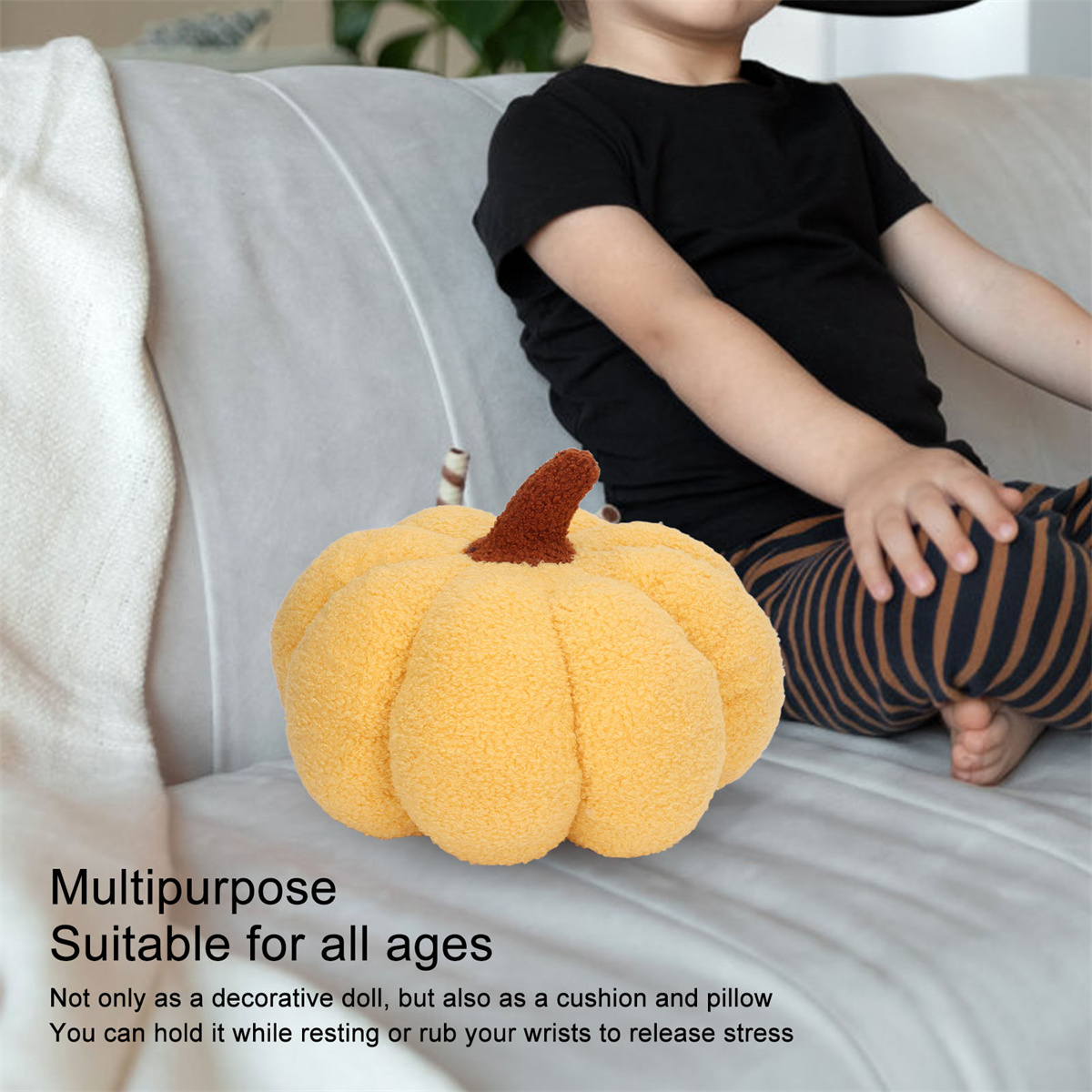 Gelbes Kürbis-Plüschtier mit braunem Stiel, auf einem Sofa, und ein Kind im Hintergrund.