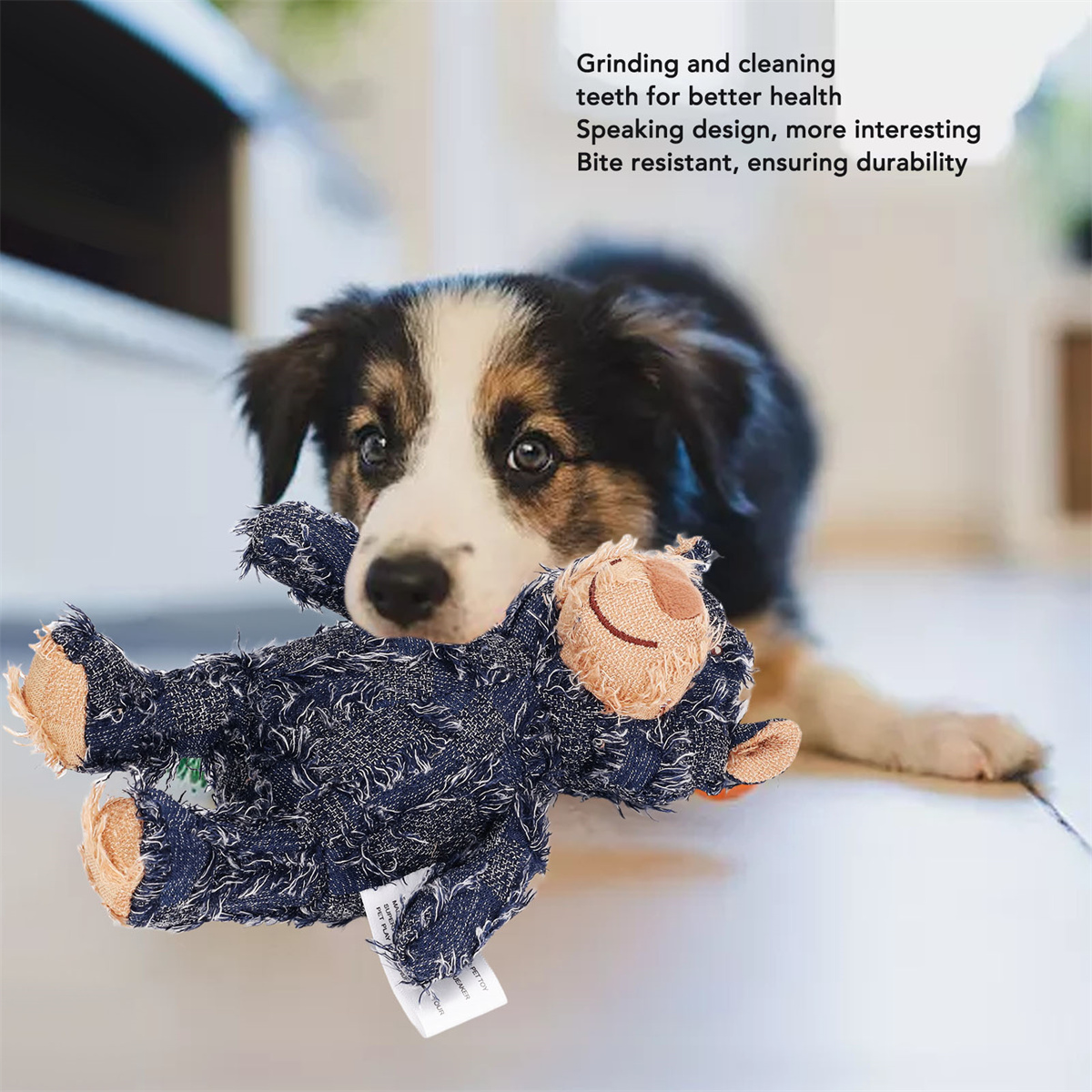 Ein Hund hält ein blaues Denim-Spielzeug im Maul. Text zum Spielzeug ist vorhanden.