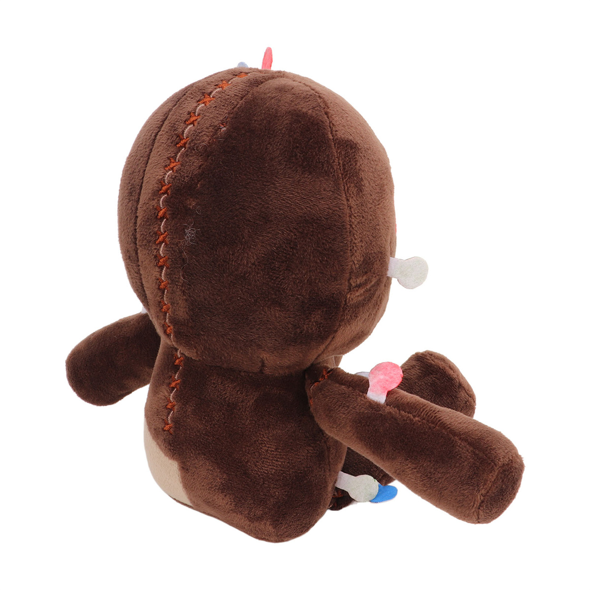 Braune Plüschpuppe im Profil, genähte Details, weißer Knochen, rosa und blau.